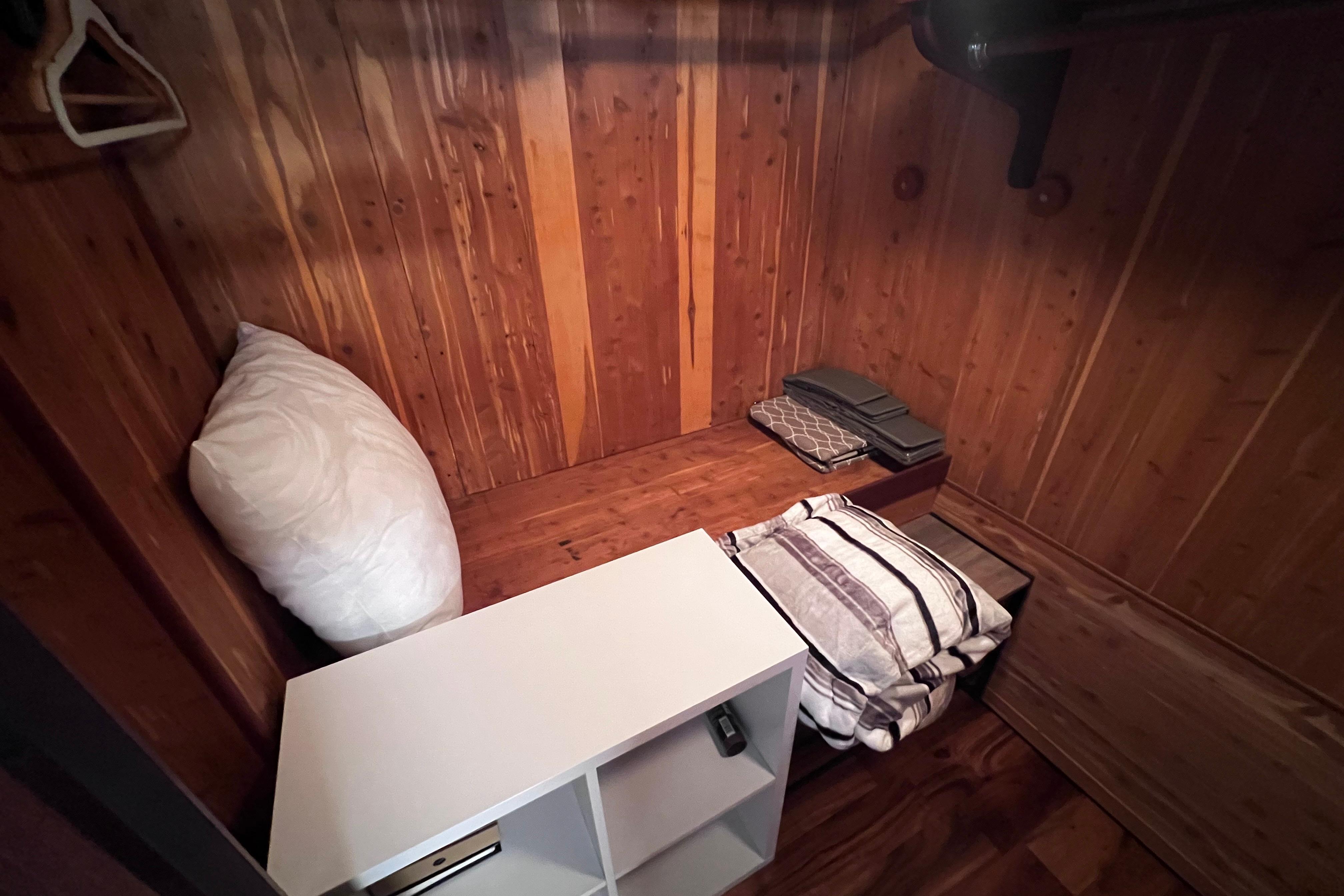 Wood-paneled storage area in 1987 Hatteras 70 Cockpit Motor Yacht with pillows and shelves.