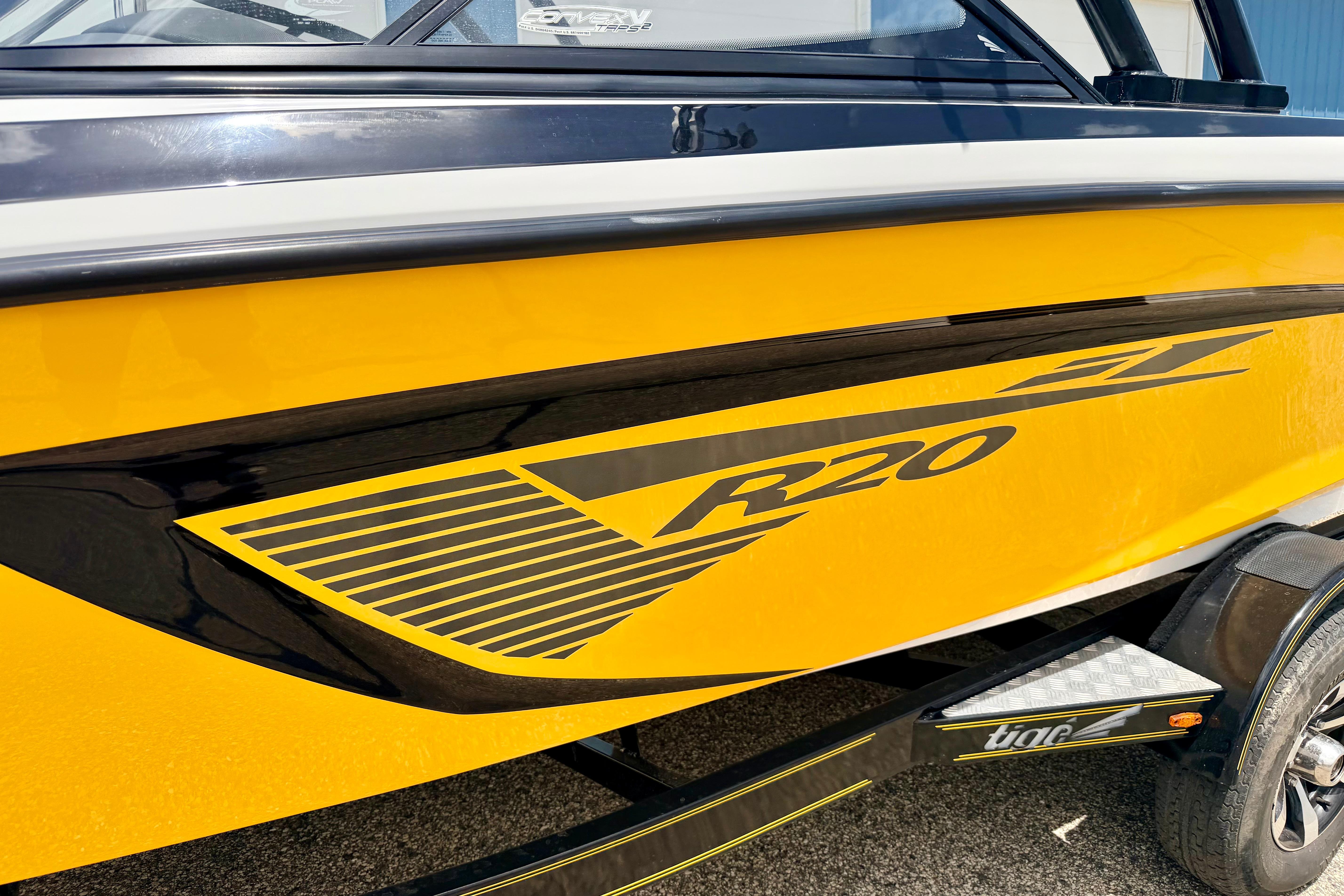 Yellow 2014 Tigé R20 boat with black detailing on a trailer.