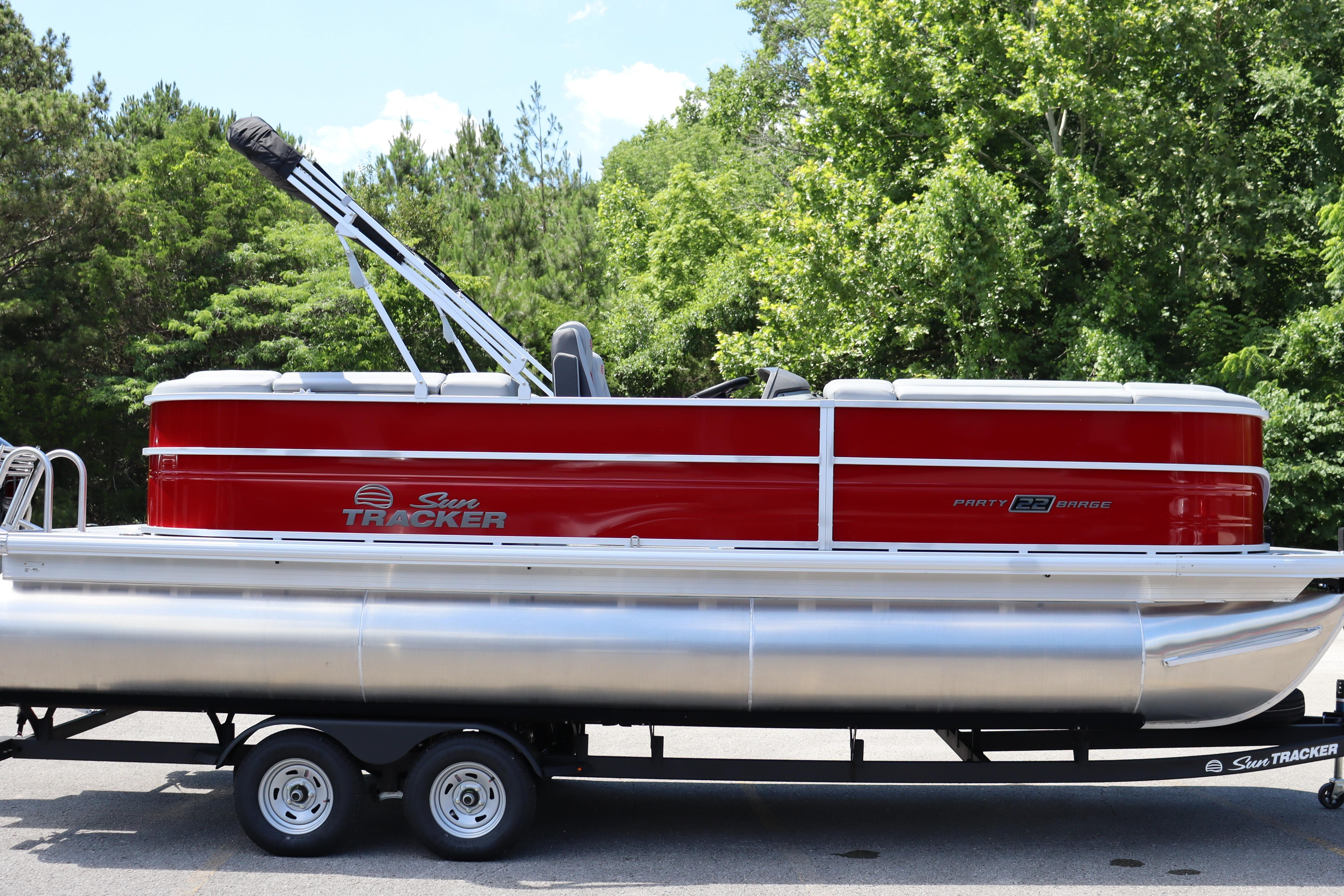 2026 Sun Tracker Party Barge 22 XP3 pontoon boat on trailer, surrounded by trees.