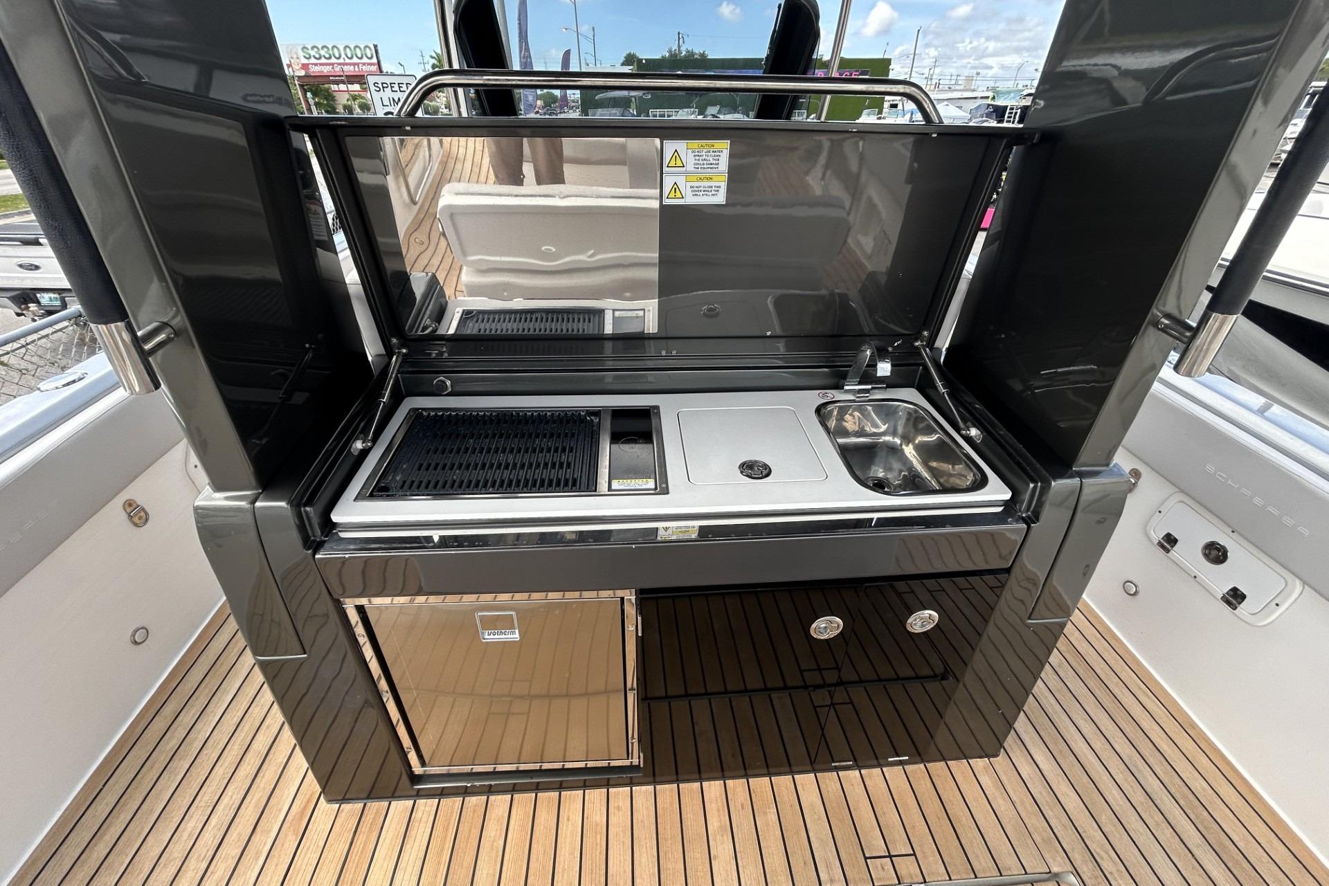 Outdoor kitchen on 2023 Schaefer V33 yacht with grill, sink, and storage.