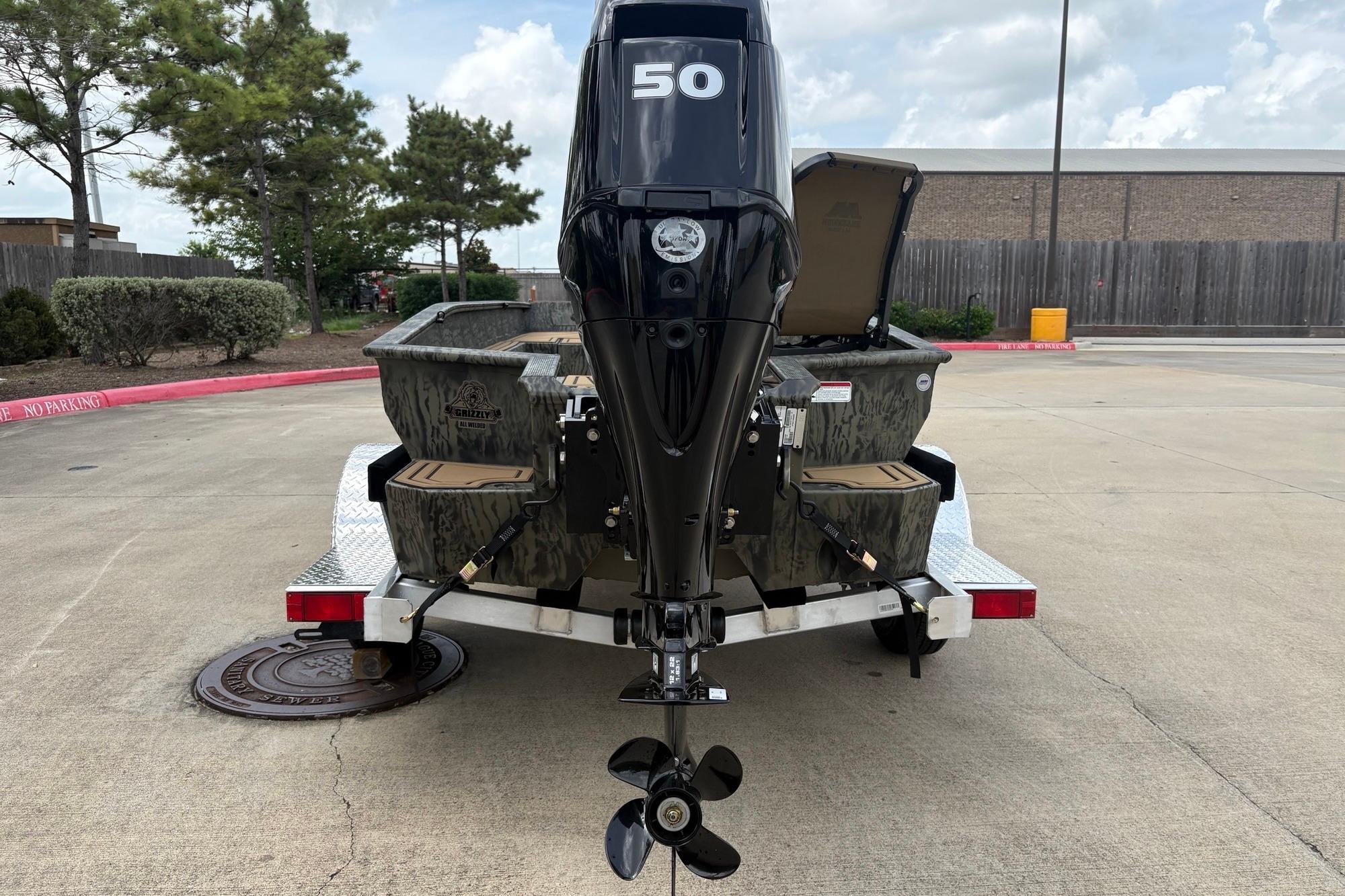 2026 Tracker Grizzly 1650 T Prairie Wings Edition boat on trailer, rear view with motor.
