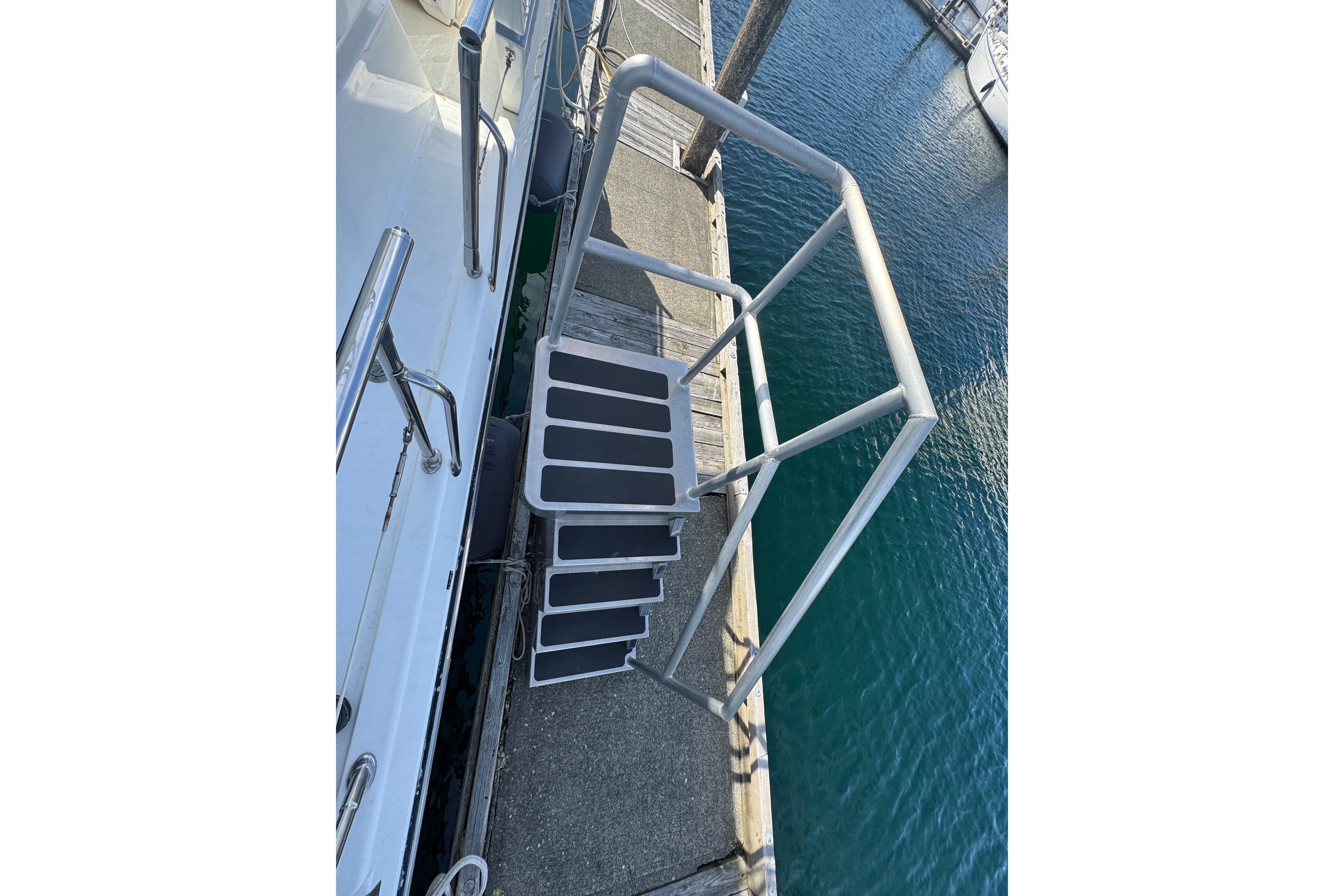 Staircase on 1994 Johnson High-Tech 65 Euro yacht, docked by the water.