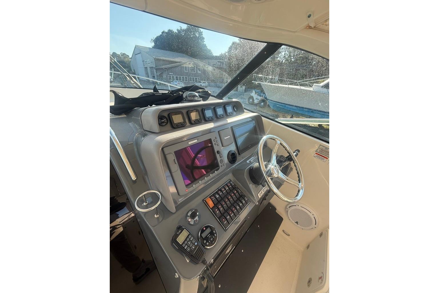 2010 Pursuit OS 375 Offshore boat helm with navigation controls and steering wheel.