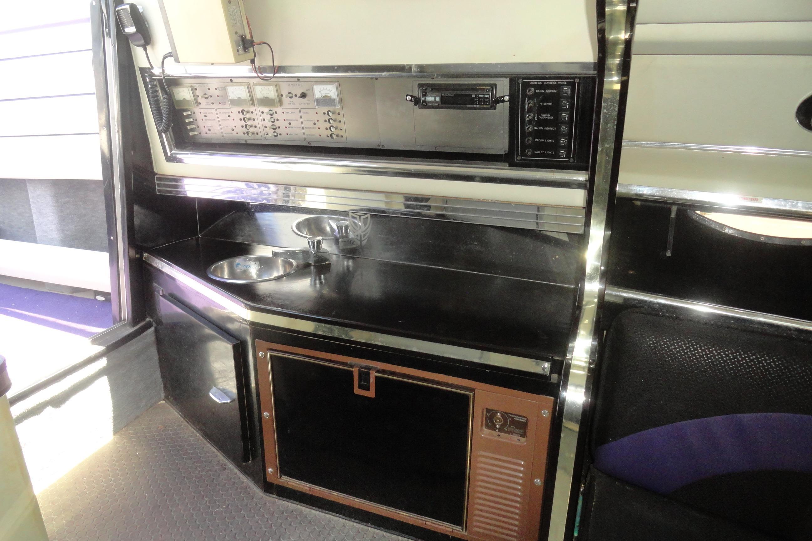 1988 Wellcraft 34 Scarab interior with control panel and kitchenette area.