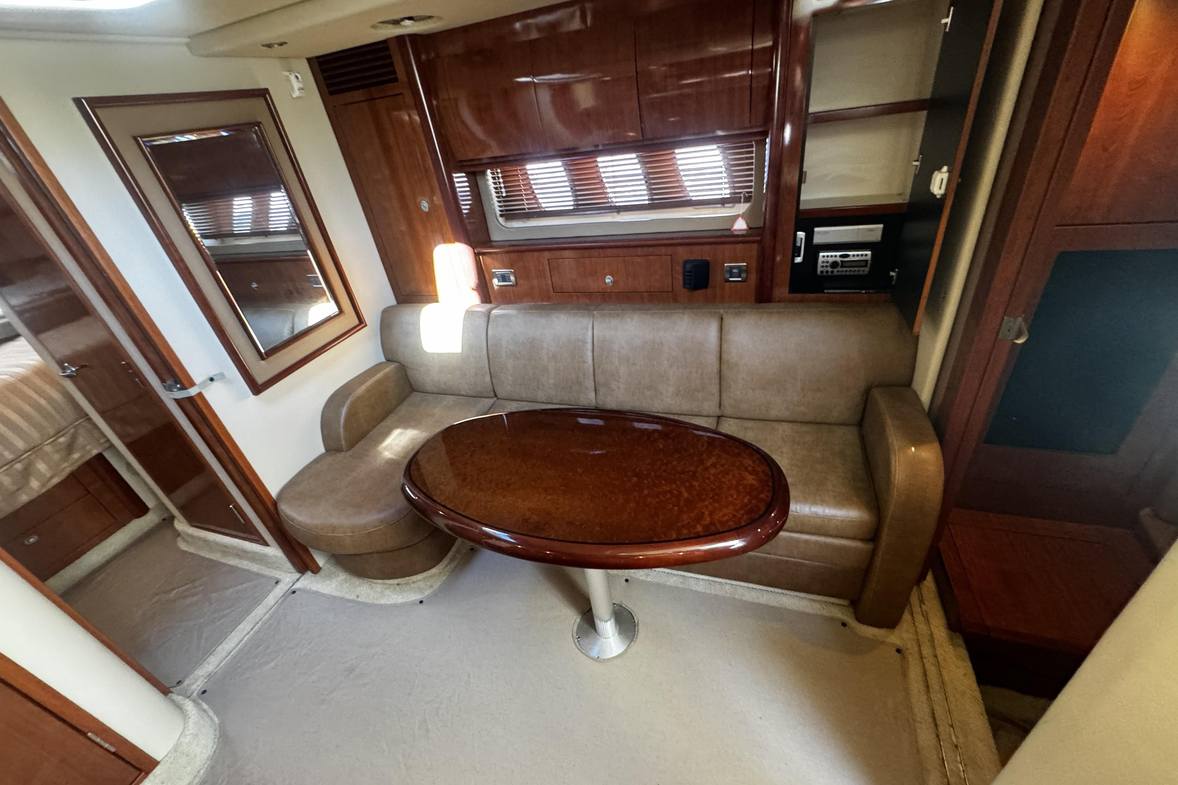 Interior of 2006 Sea Ray 40 Sundancer yacht with leather seating and wooden table.