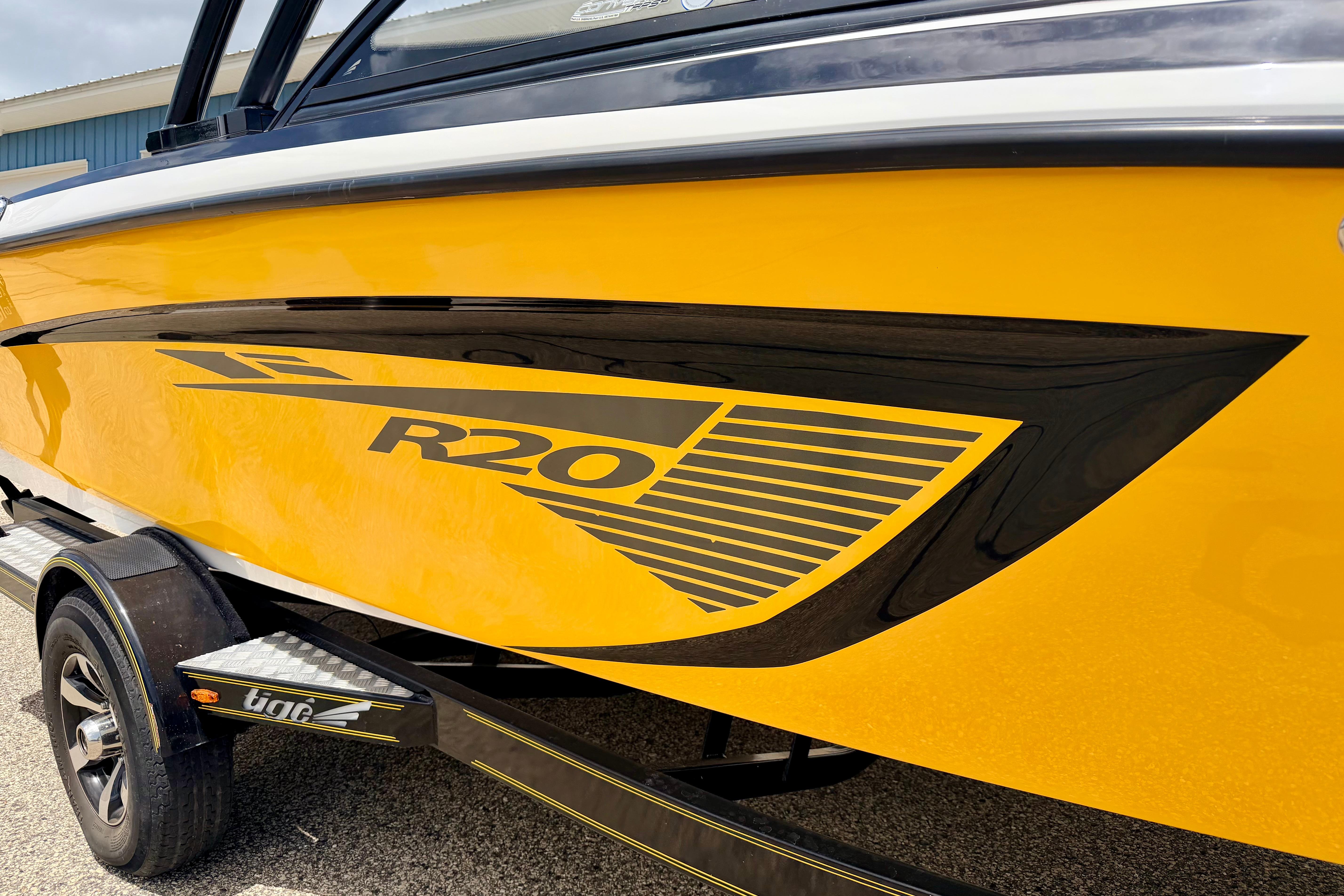 2014 Tigé R20 boat in vibrant yellow with black detailing on trailer.