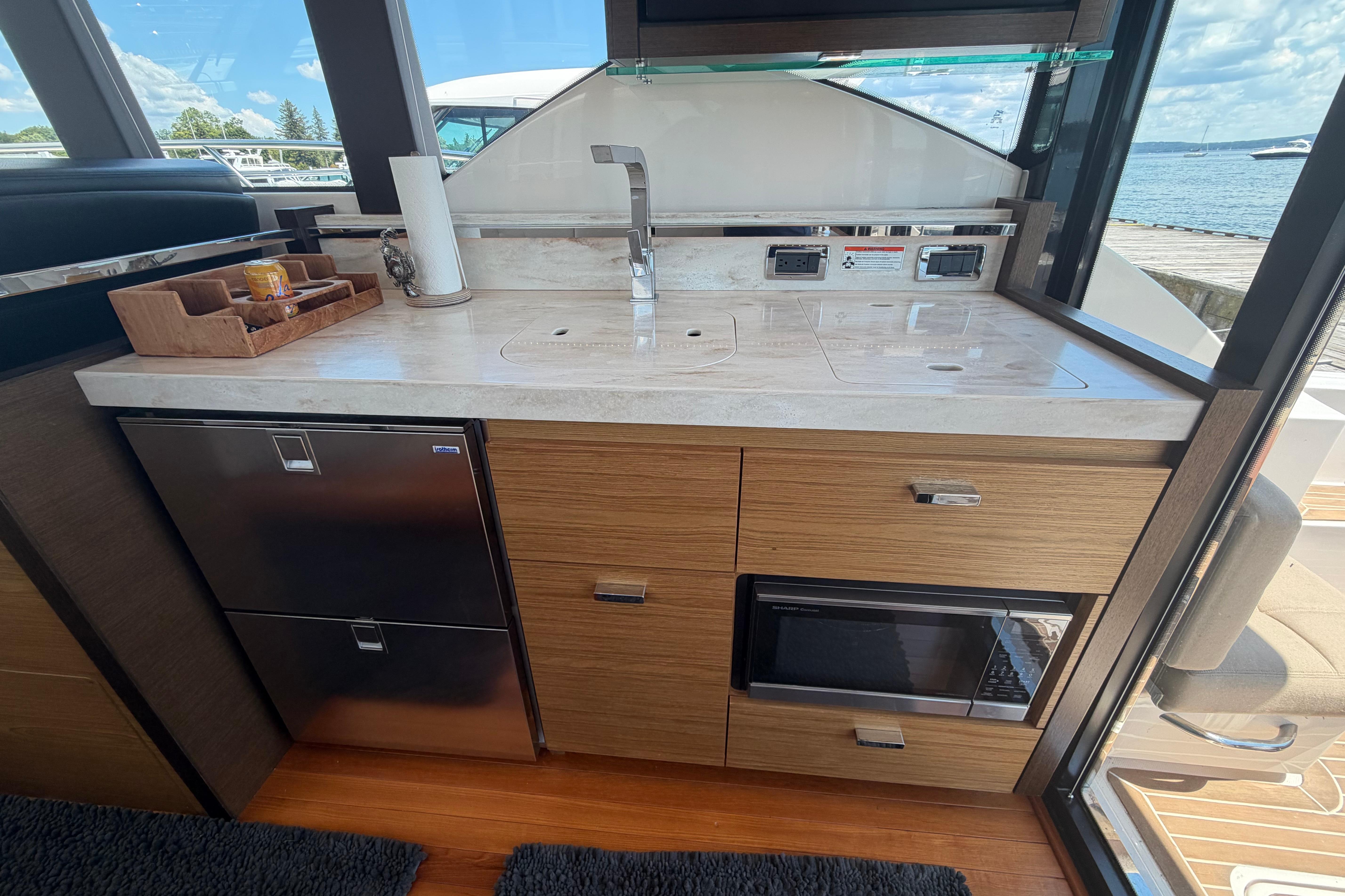 Modern kitchen area in a 2016 Tiara Yachts C39 Coupe, featuring sleek cabinetry and appliances.