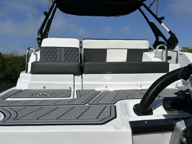 The image shows the rear of a modern boat with gray and white seating.