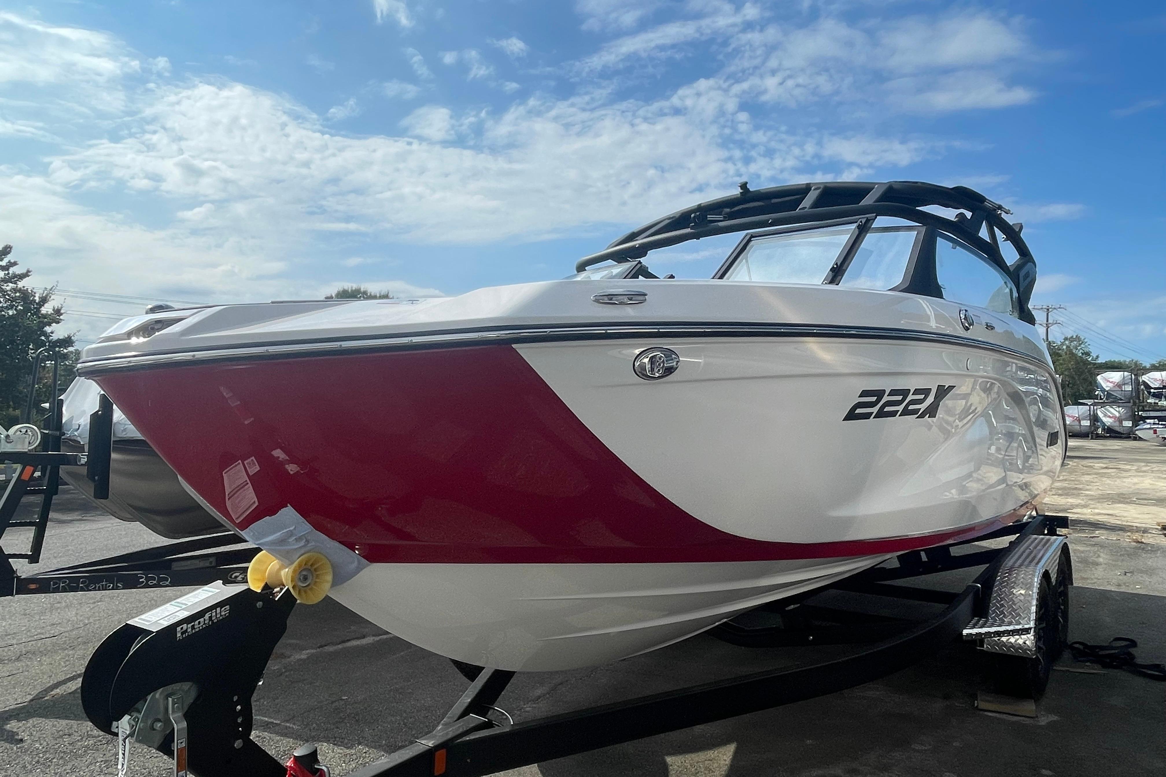 2026 Yamaha Boats 222XD on trailer, red and white design, under a clear blue sky.