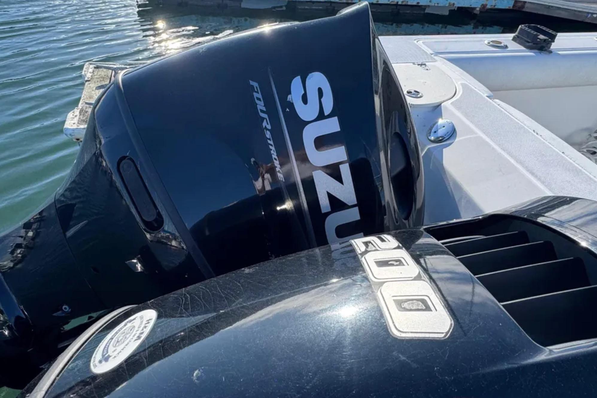 Outboard motors on a 2004 Boston Whaler 255 Conquest boat, docked by the water.