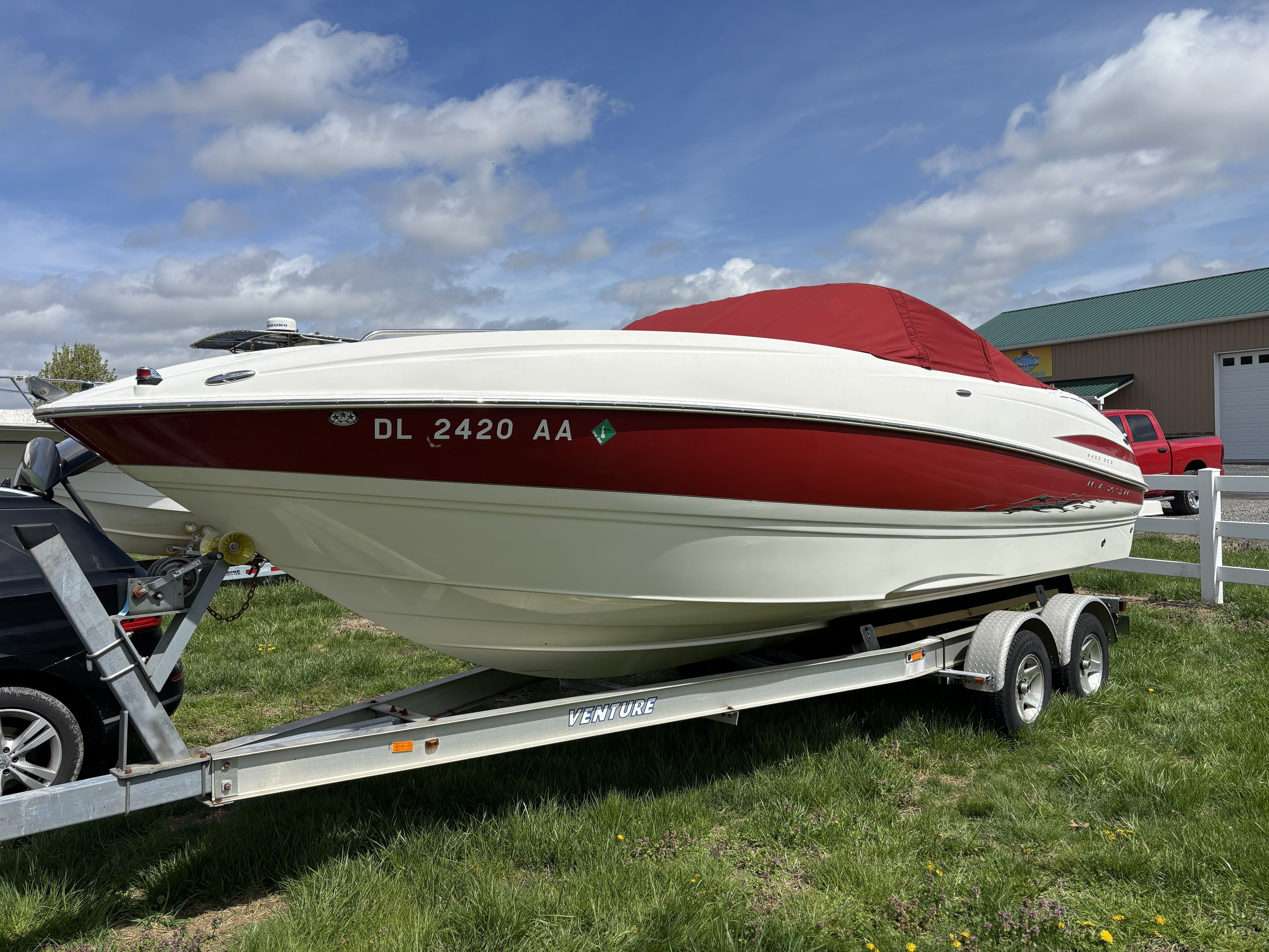 2005 Maxum 2400 SC3 boat on trailer, red and white.