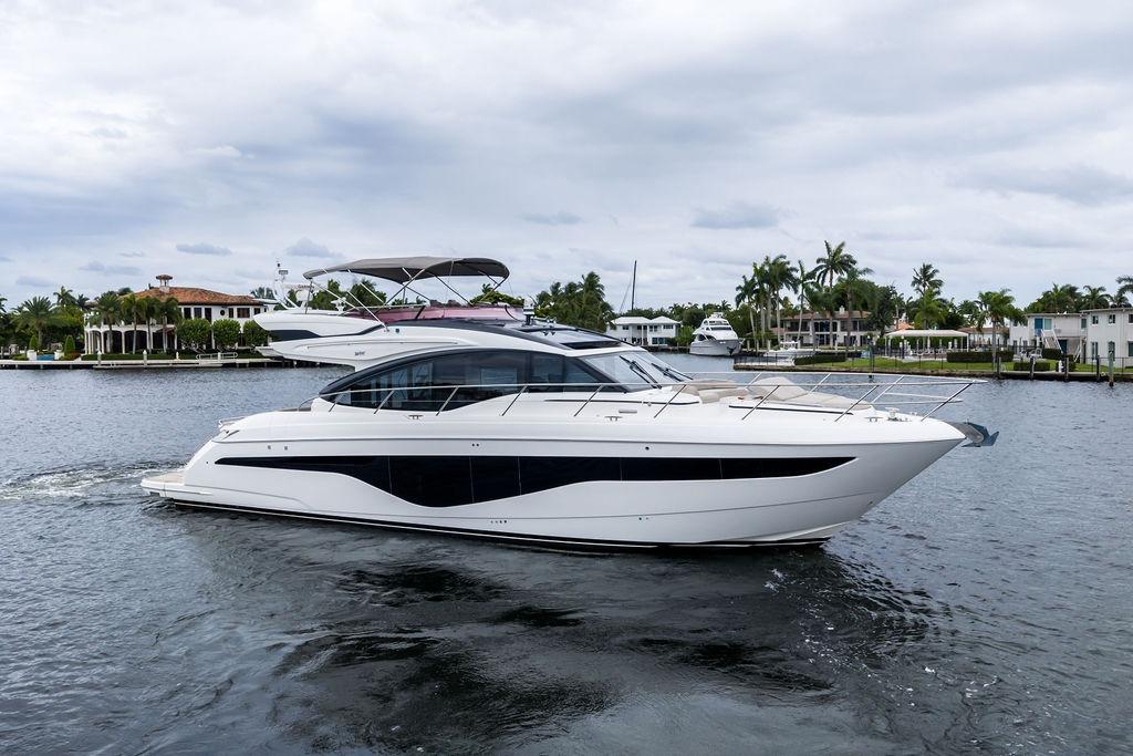 Luxury 2020 Princess S62 yacht cruising on a serene waterfront.