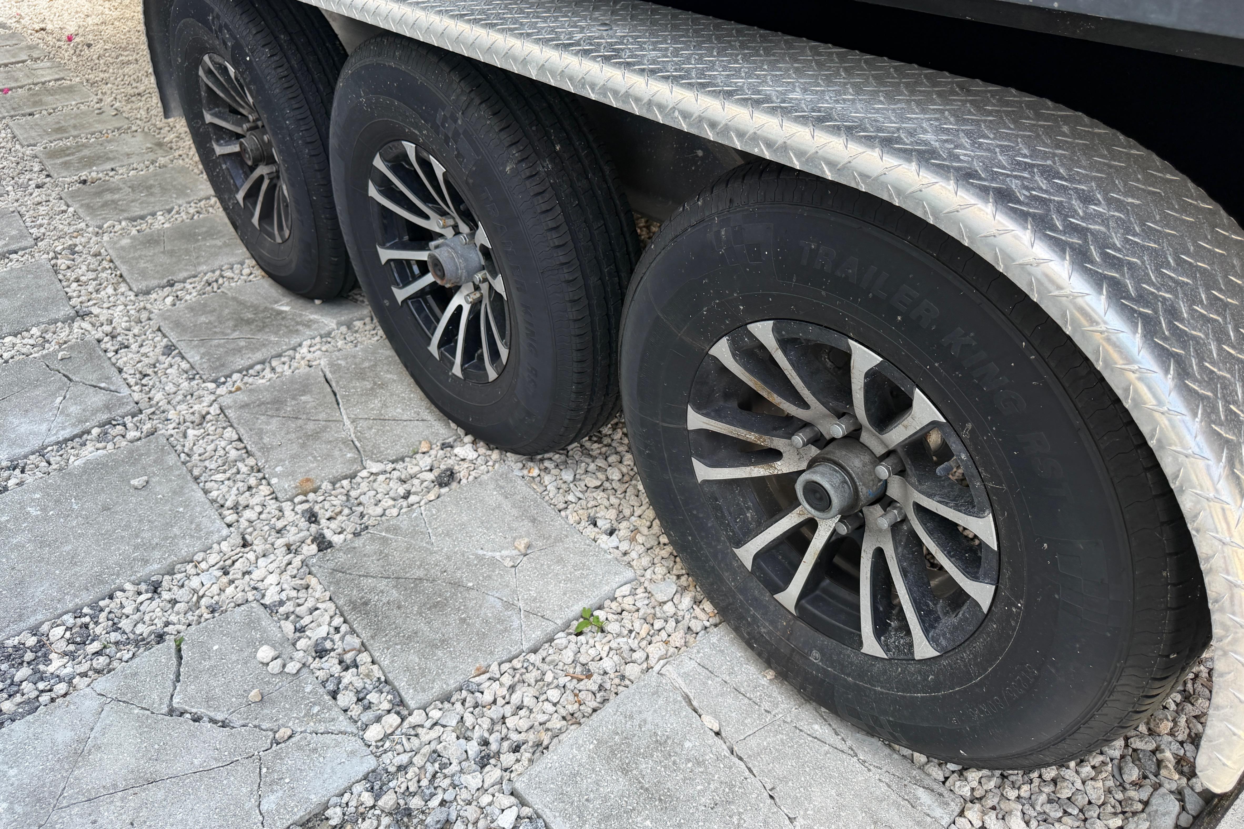 Trailer wheels on gravel, supporting a 2008 Hydra-Sports Vector 2900 CC boat.
