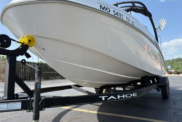2024 Tahoe T21 boat on trailer in parking lot, side view.
