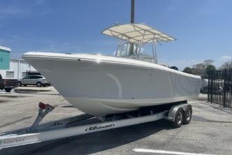 2023 Sailfish 242 CC boat on trailer under clear blue sky.