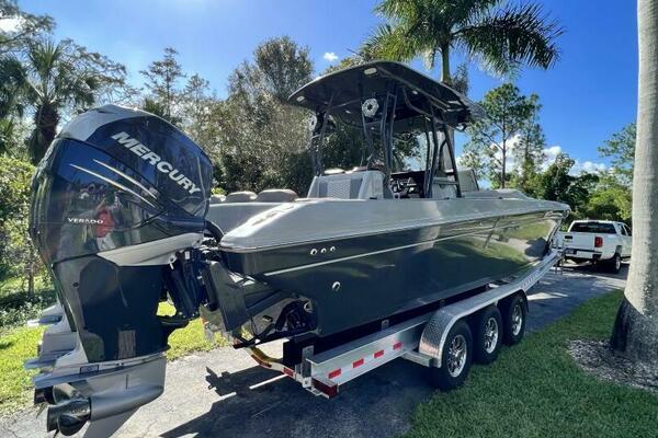 1996 Formula 382 SR1 boat on trailer with Mercury engine, surrounded by trees.
