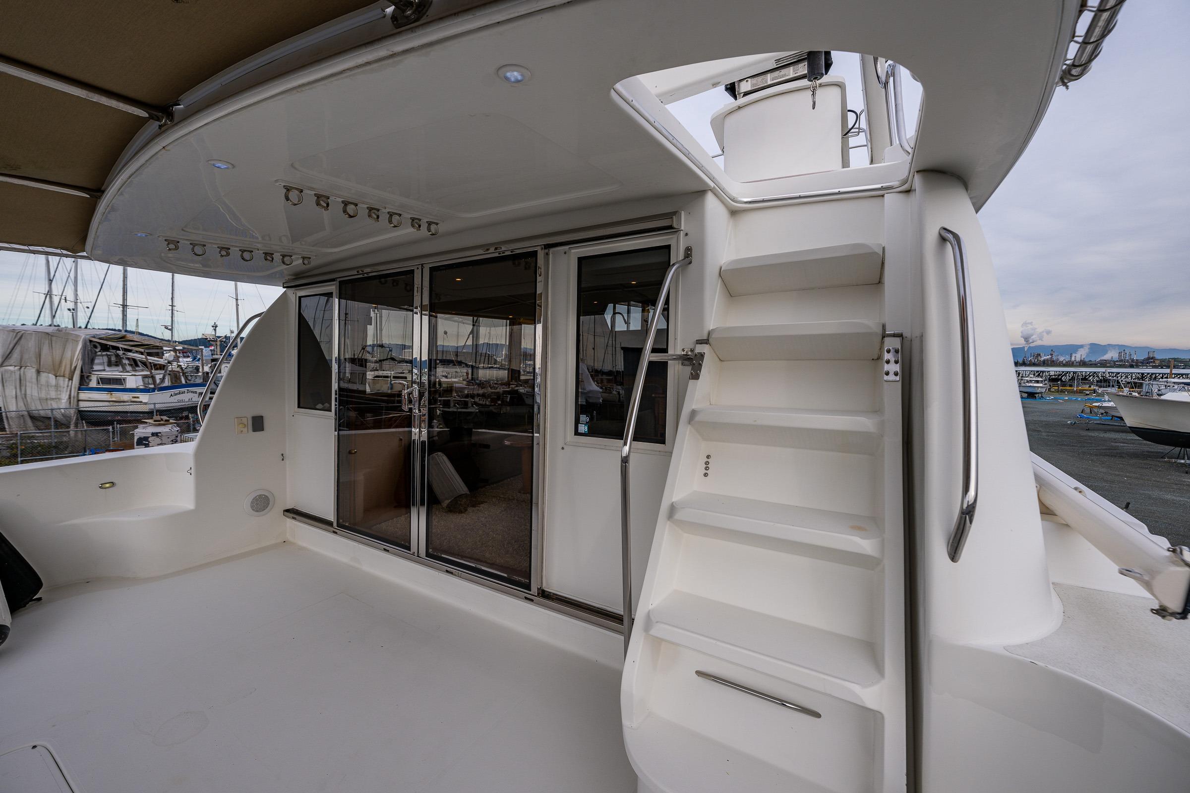 2001 Navigator Pilothouse yacht deck with stairs and sliding glass doors.