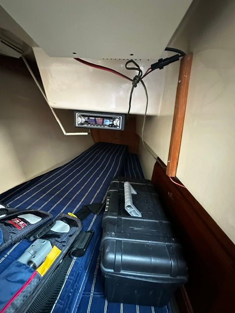 Interior of a 1985 Catalina 27 with a toolbox and striped carpet.