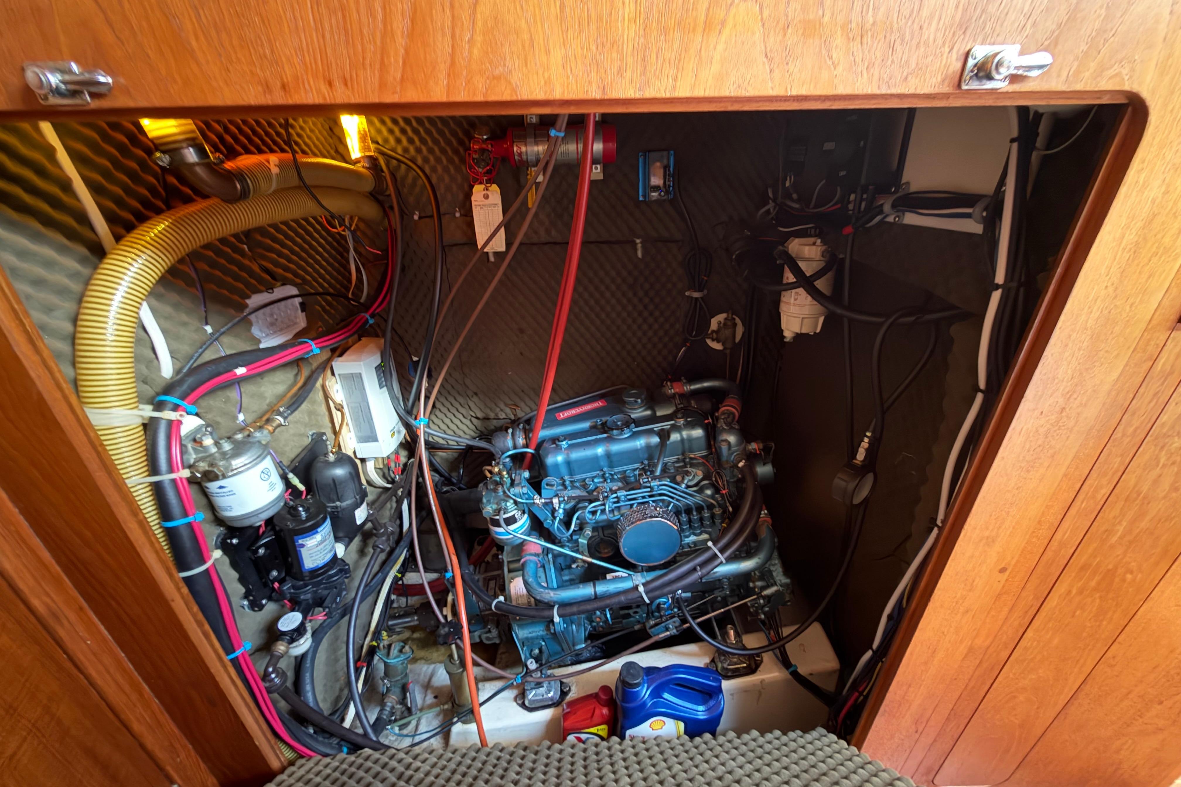 Engine compartment of a 1987 Moody 376 sailboat, showcasing wiring and components.