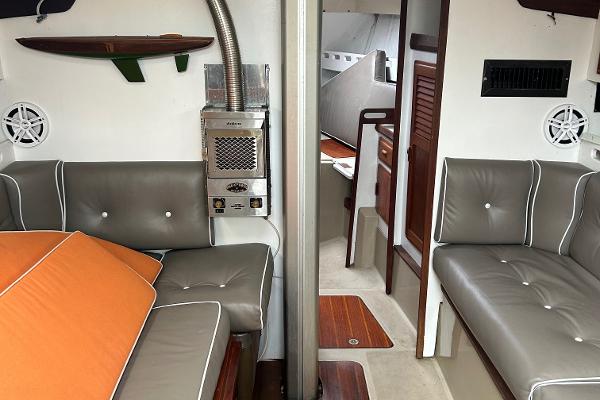 Interior of 1983 O'Day 39 sailboat with gray seating and orange cushions.