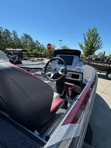 2025 Nitro Z20 XL Pro boat interior with steering wheel, dashboard, and seating under clear blue sky.