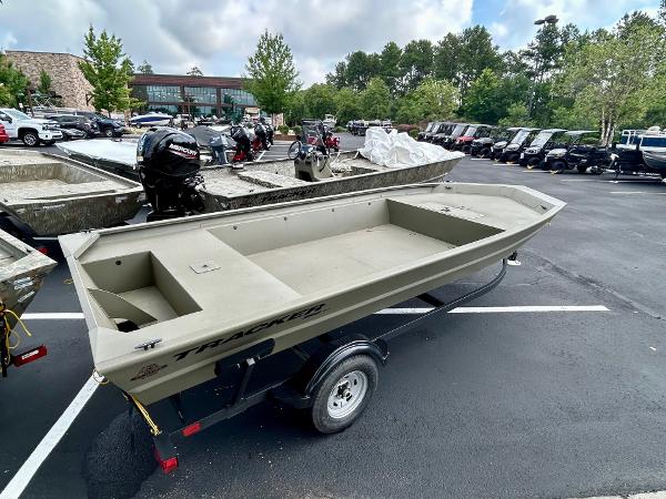 2025 Tracker GRIZZLY 1860 Utility boat on trailer in parking lot.