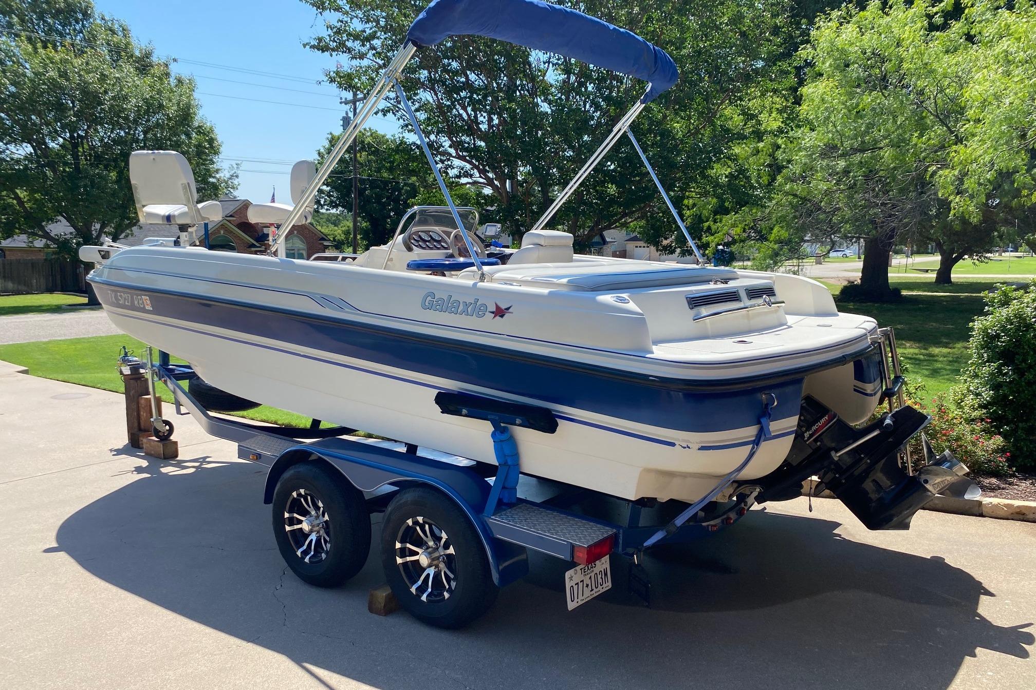 2003 Galaxie 2100 Ultra F & S boat on trailer, parked in sunny driveway.