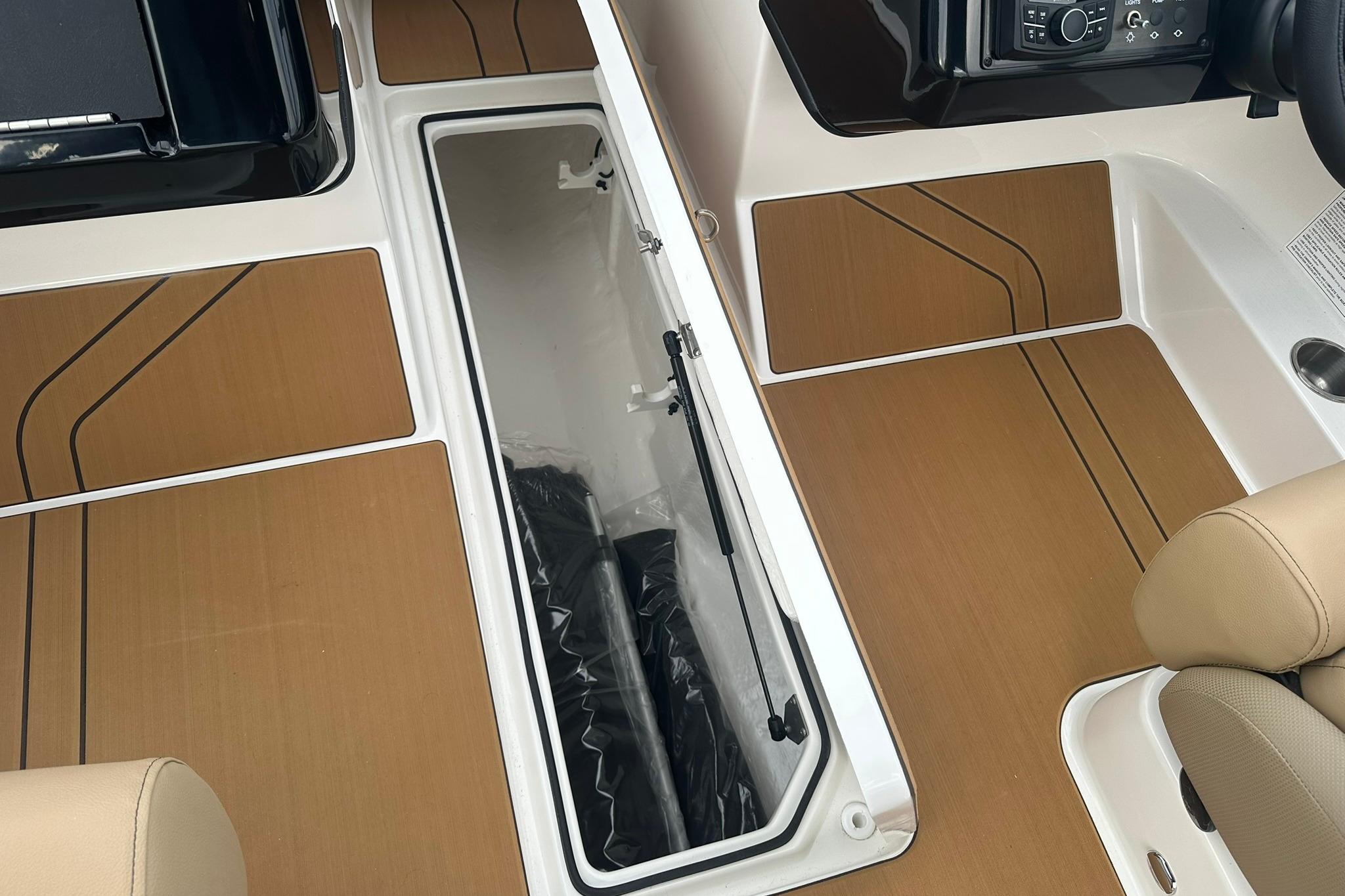 2026 Bayliner V20 boat interior with open storage compartment and modern dashboard.