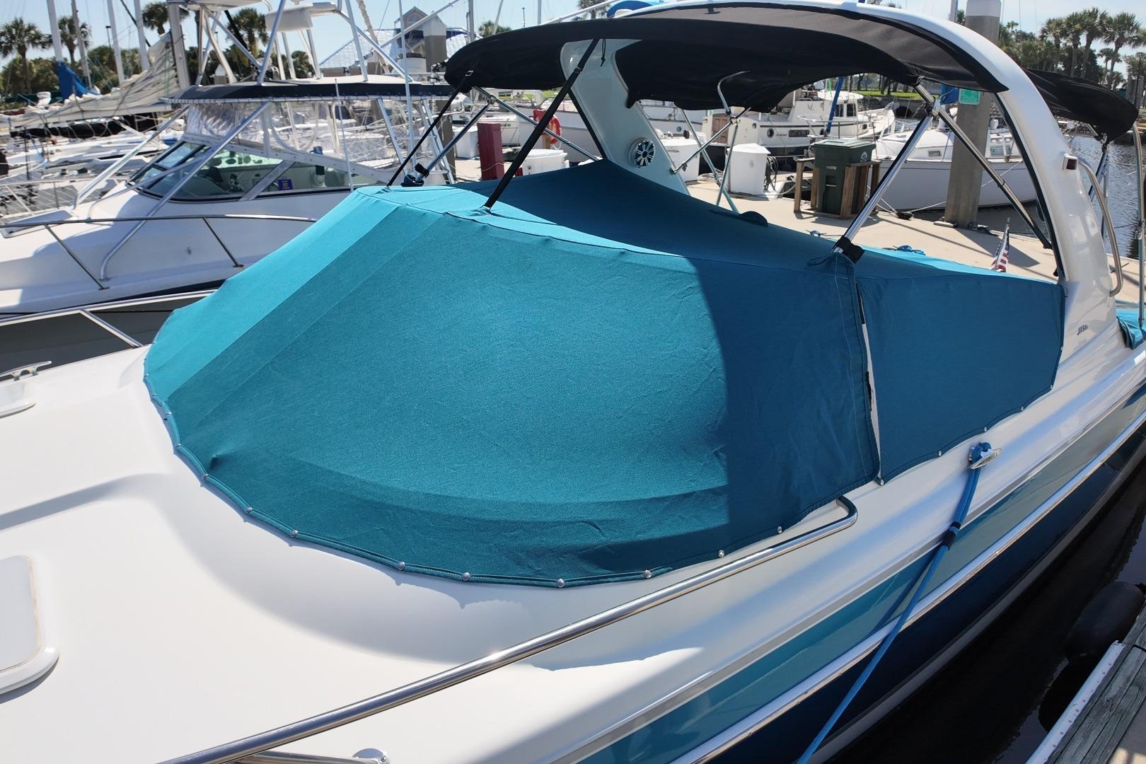 2007 Formula 330 Sun Sport boat with blue cover docked at marina.