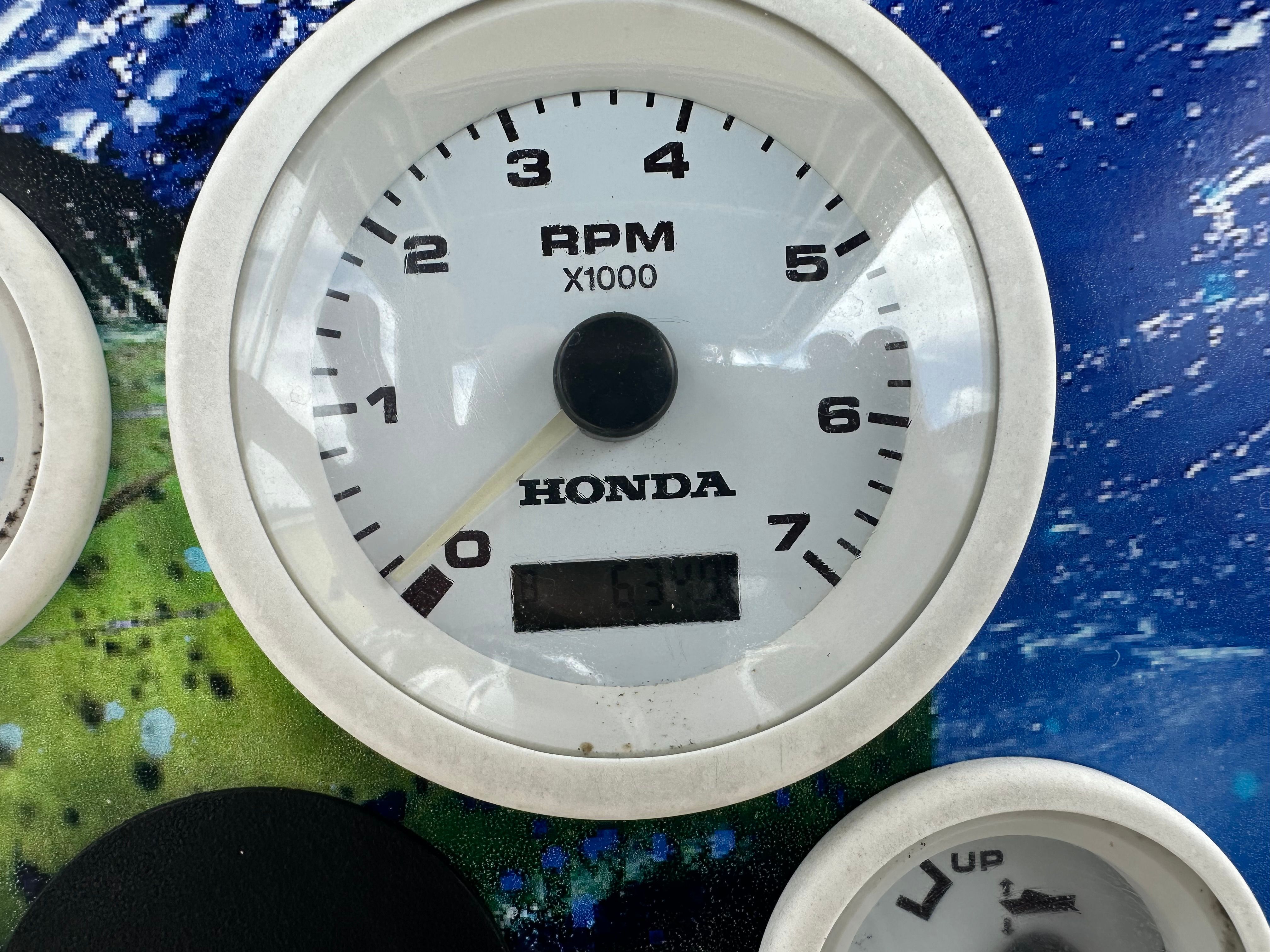 Close-up of a Honda tachometer on a boat, displaying 6300 RPM.