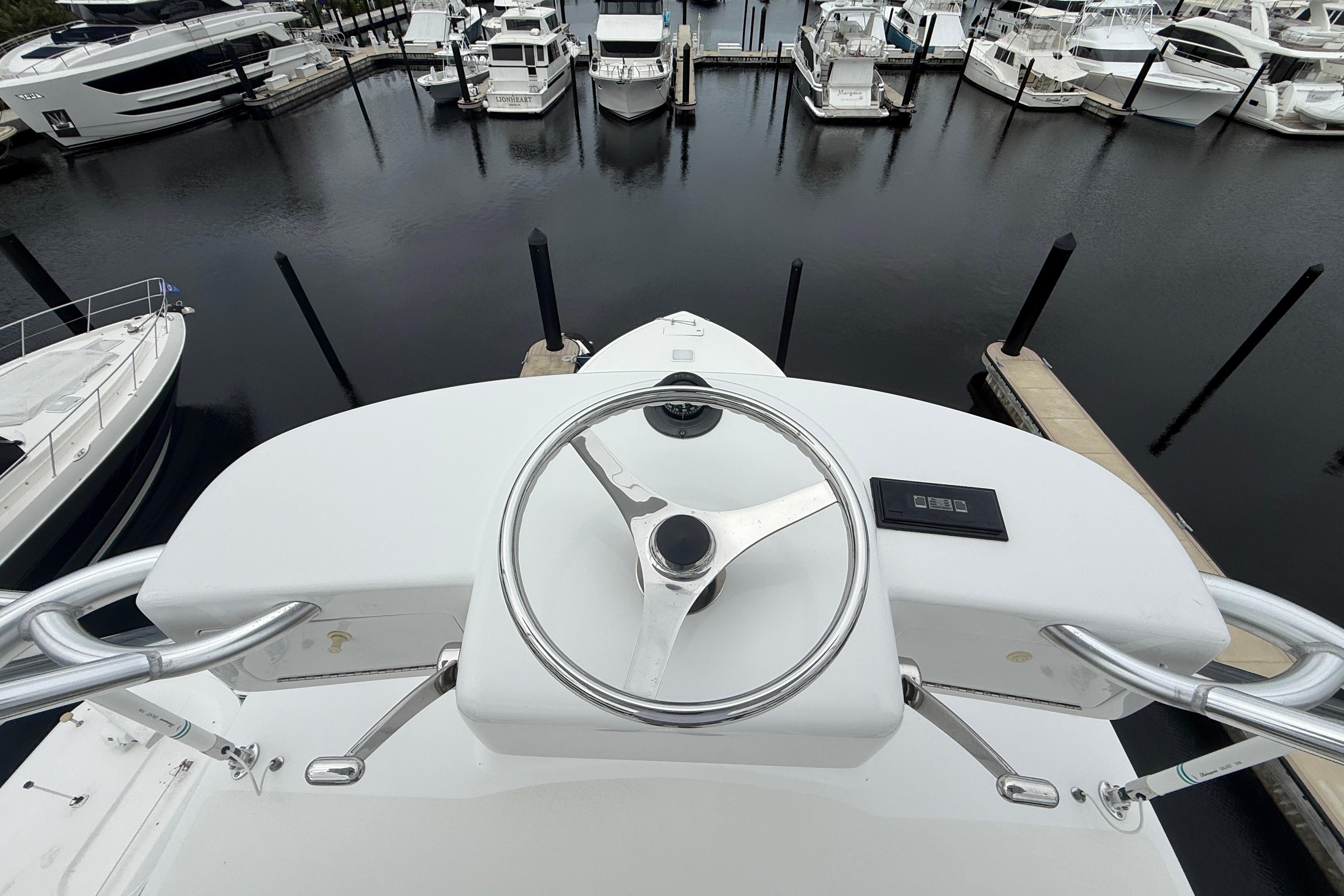 Helm view of a 2000 Viking 55 Convertible yacht docked at a marina.