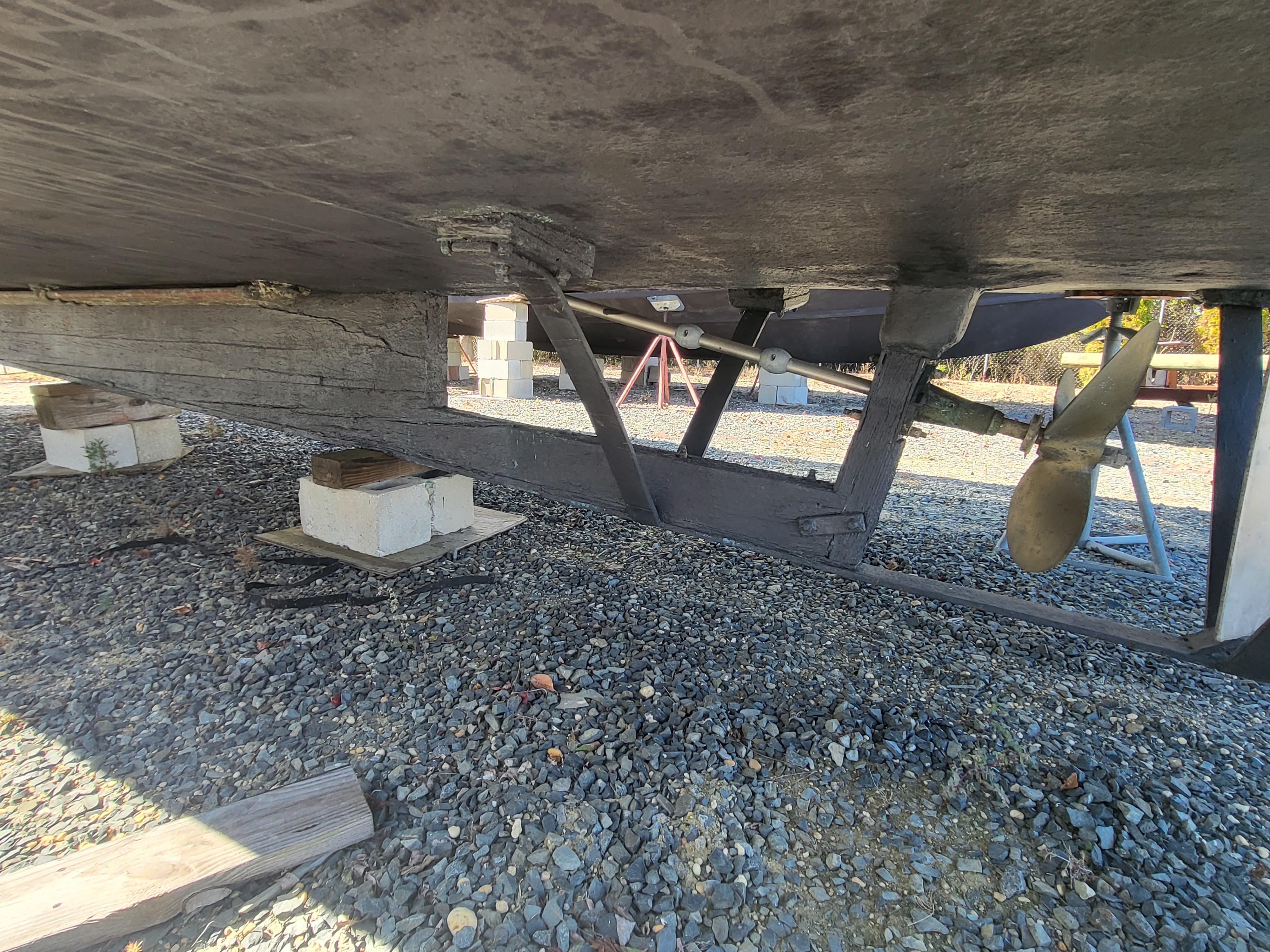 Underside of 1985 Kinnamon Pilot House Chesapeake Deadrise boat on gravel.