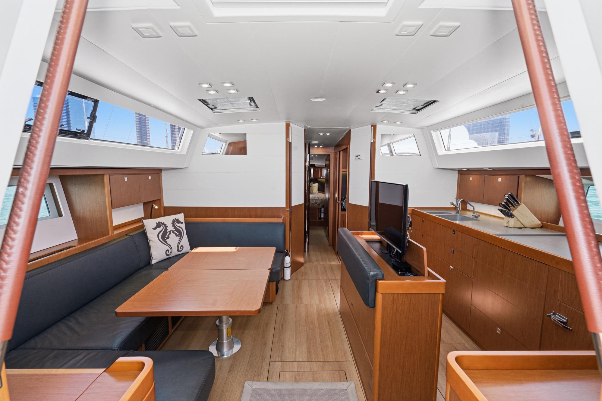 Interior of 2017 Beneteau Sense 50 yacht, featuring modern wood finishes and spacious seating area.