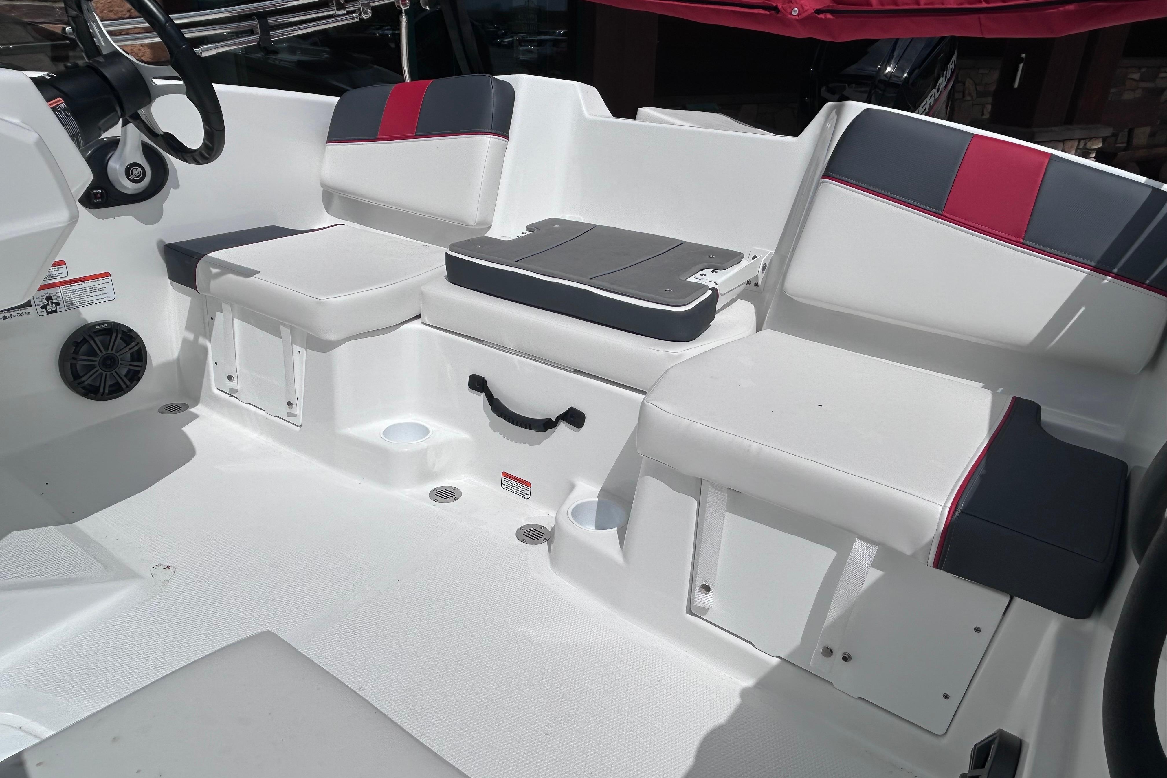 2026 Tahoe T16 boat interior with white and red seating, steering wheel, and speaker.