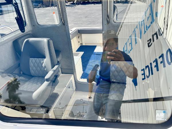 2023 Defiance Admiral 220 EX boat interior with seating and reflection.