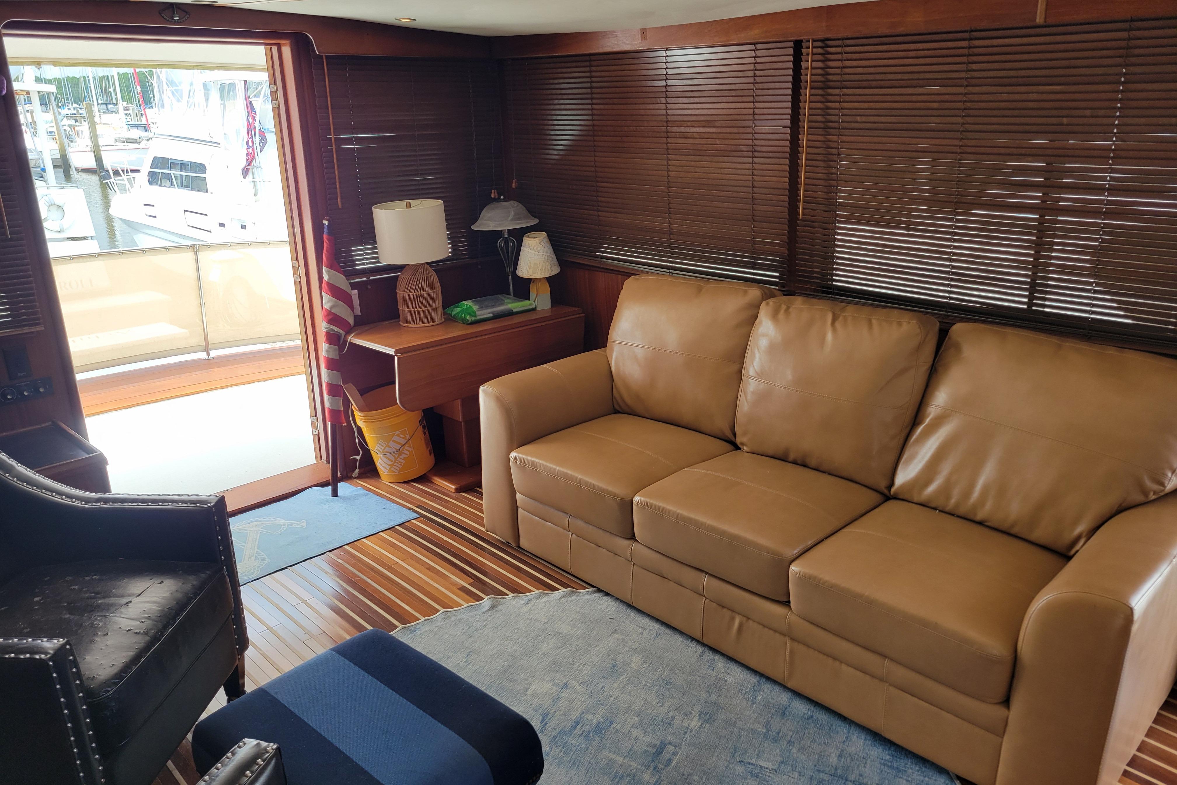 Interior of 1980 Hatteras 53 Yacht Fisherman with leather sofa and wooden blinds.