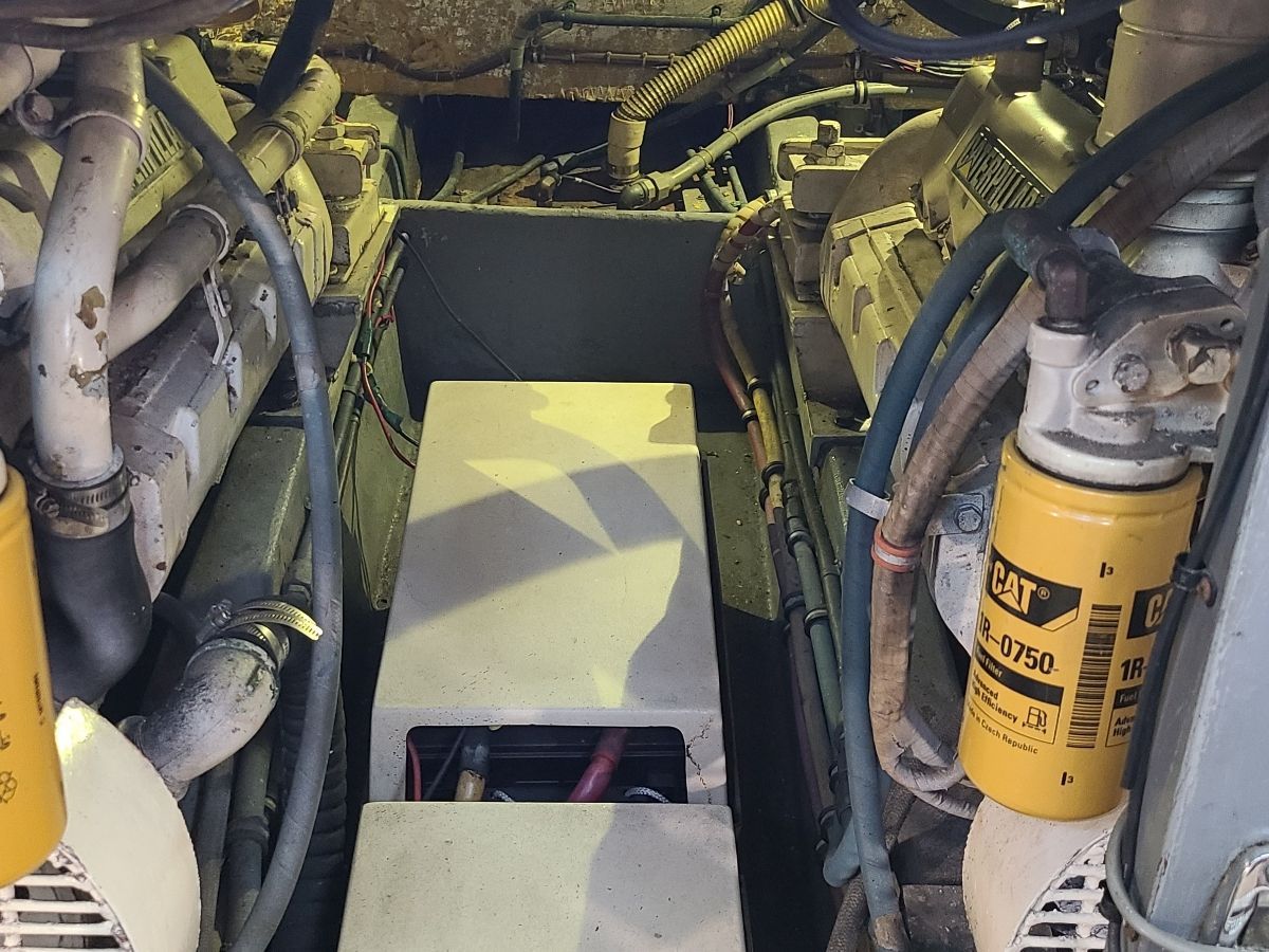 Engine room of a Hatteras yacht with visible engines and hoses.