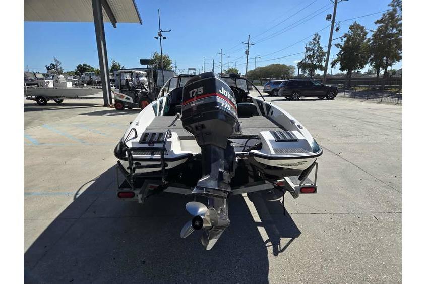 1997 Javelin 389 FS boat with Johnson 175 outboard motor in a parking lot.