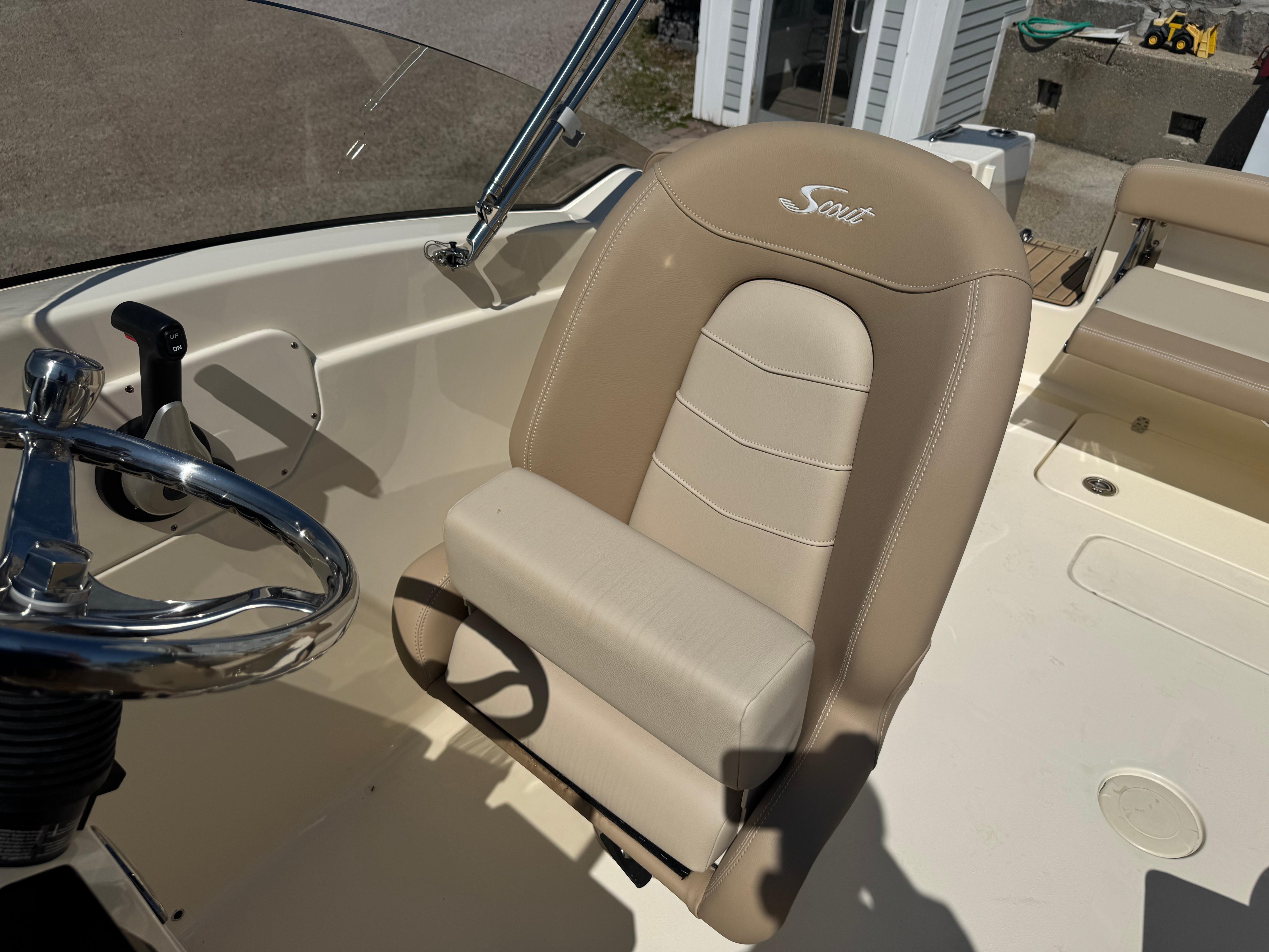 2025 Scout 215 Dorado boat interior with beige captain's seat and steering wheel.