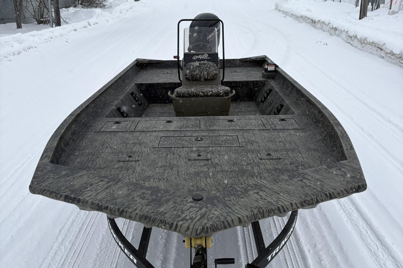 2025 Tracker Grizzly 2072 CC boat on snowy road, showcasing spacious deck design.