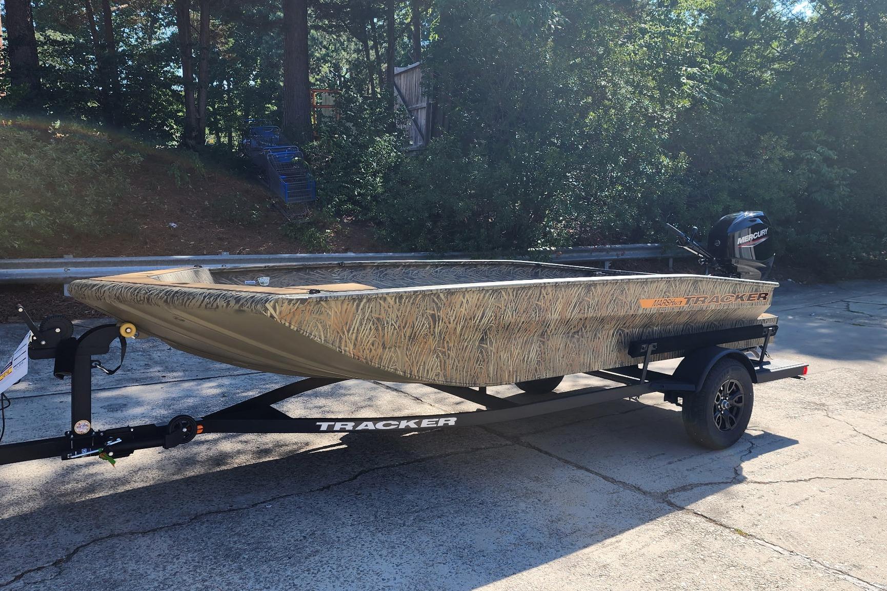 2026 Tracker Grizzly 1756 T Marsh boat on trailer, camo design, parked outdoors.
