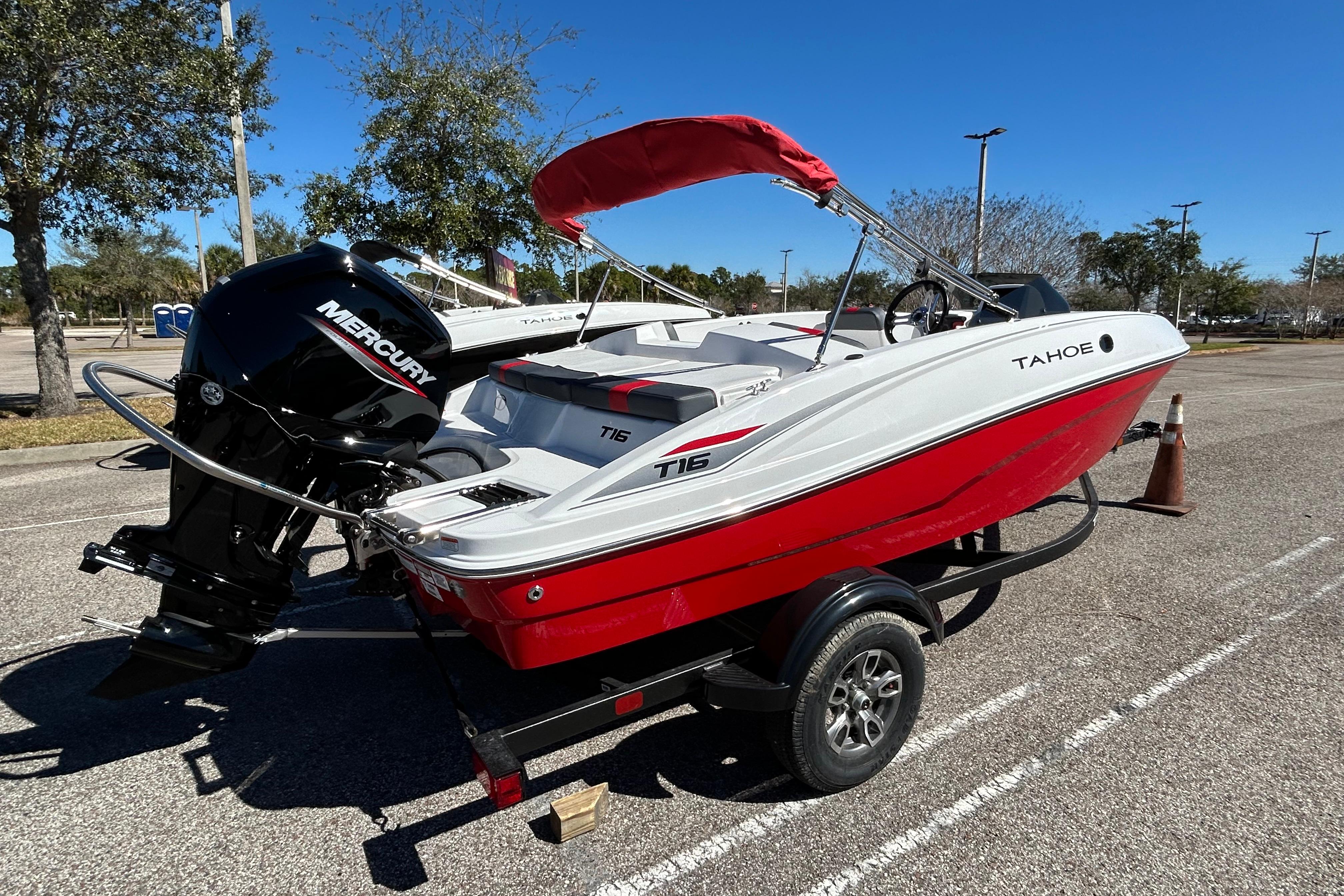 2026 Tahoe T16 boat with Mercury engine on trailer, parked outdoors.