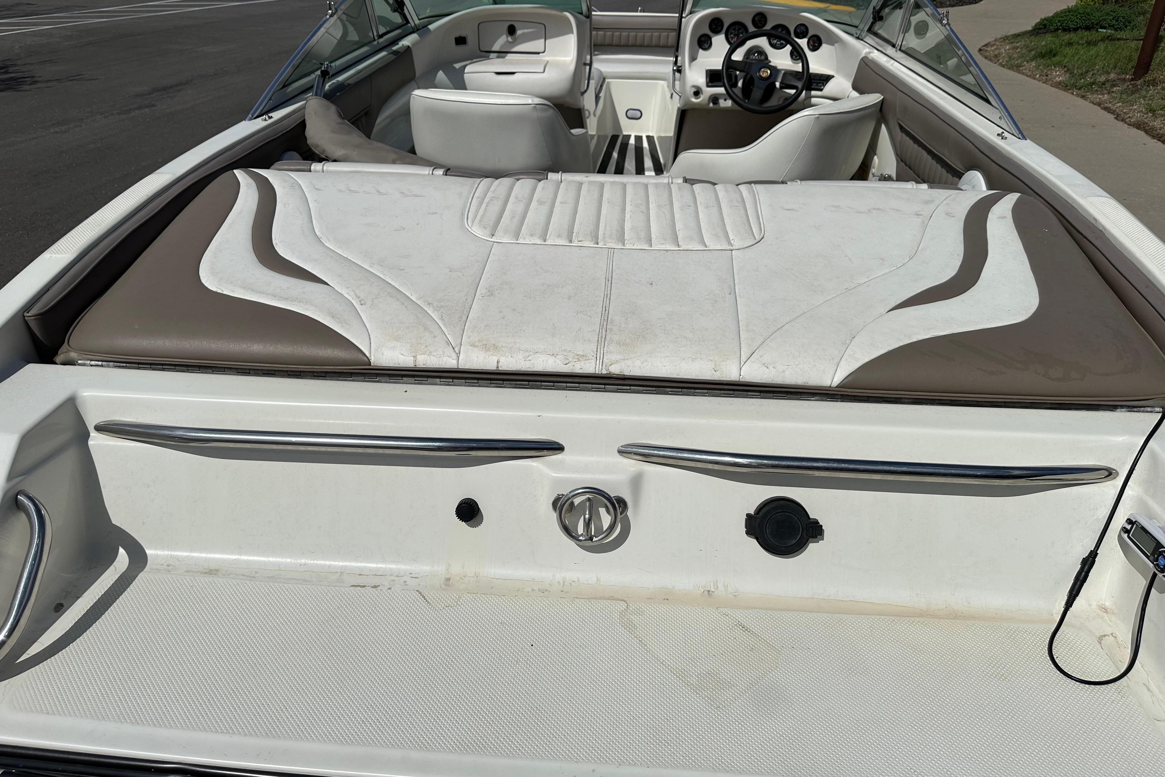1995 Mariah 180 Shabah boat interior with white and brown seating, steering wheel, and dashboard.