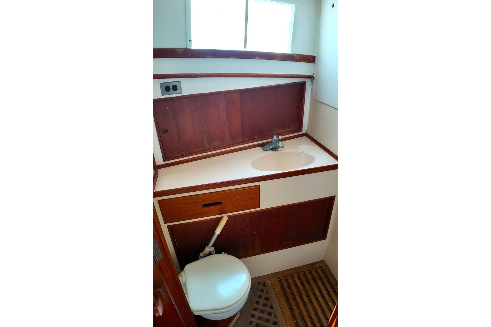 1978 Grand Banks 42 Classic yacht bathroom with wooden cabinetry and compact design.