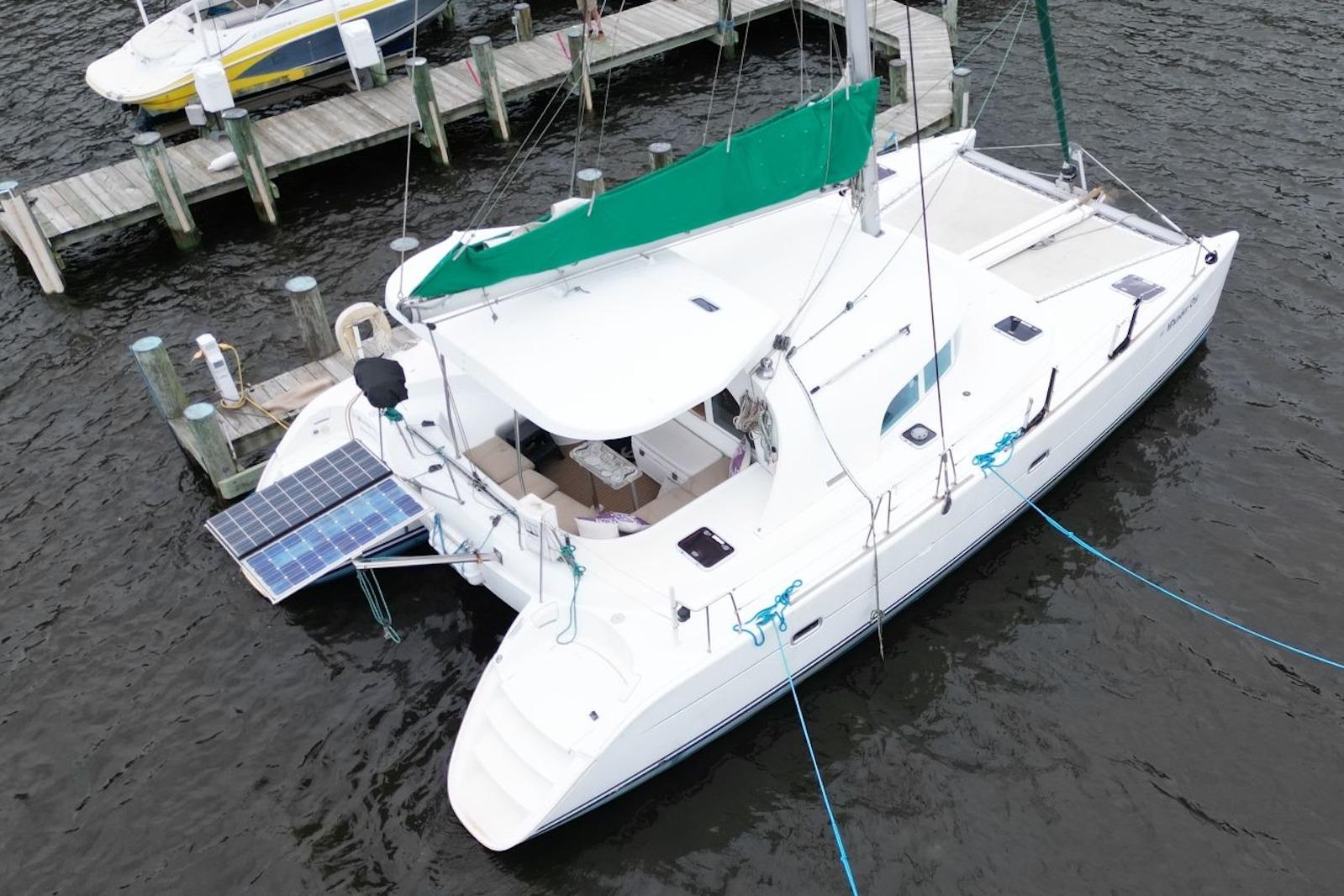 Aerial view of a 2004 Lagoon 380 catamaran docked with solar panels.