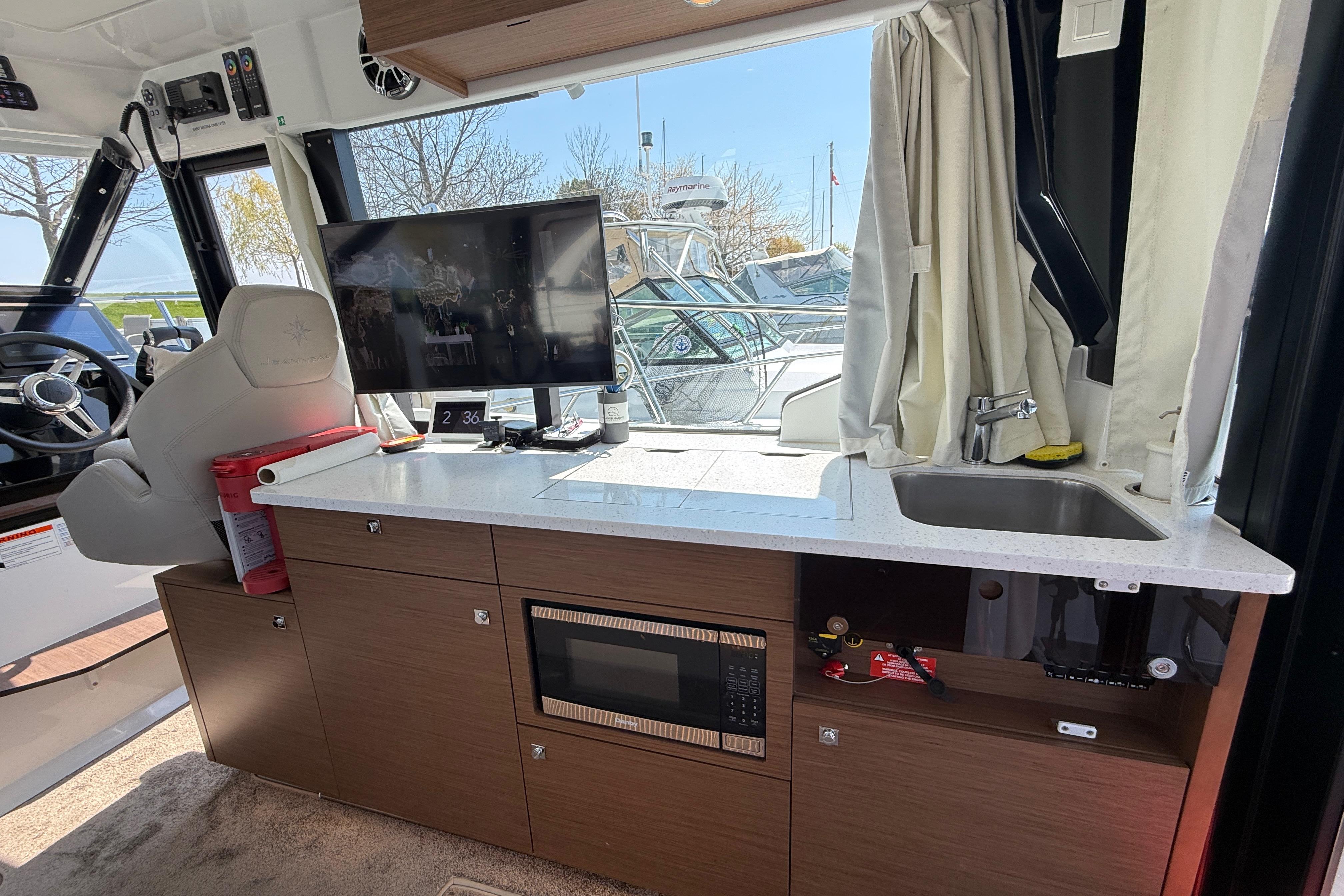 Interior of 2022 Jeanneau NC 1095 Fly with modern kitchenette and helm station.