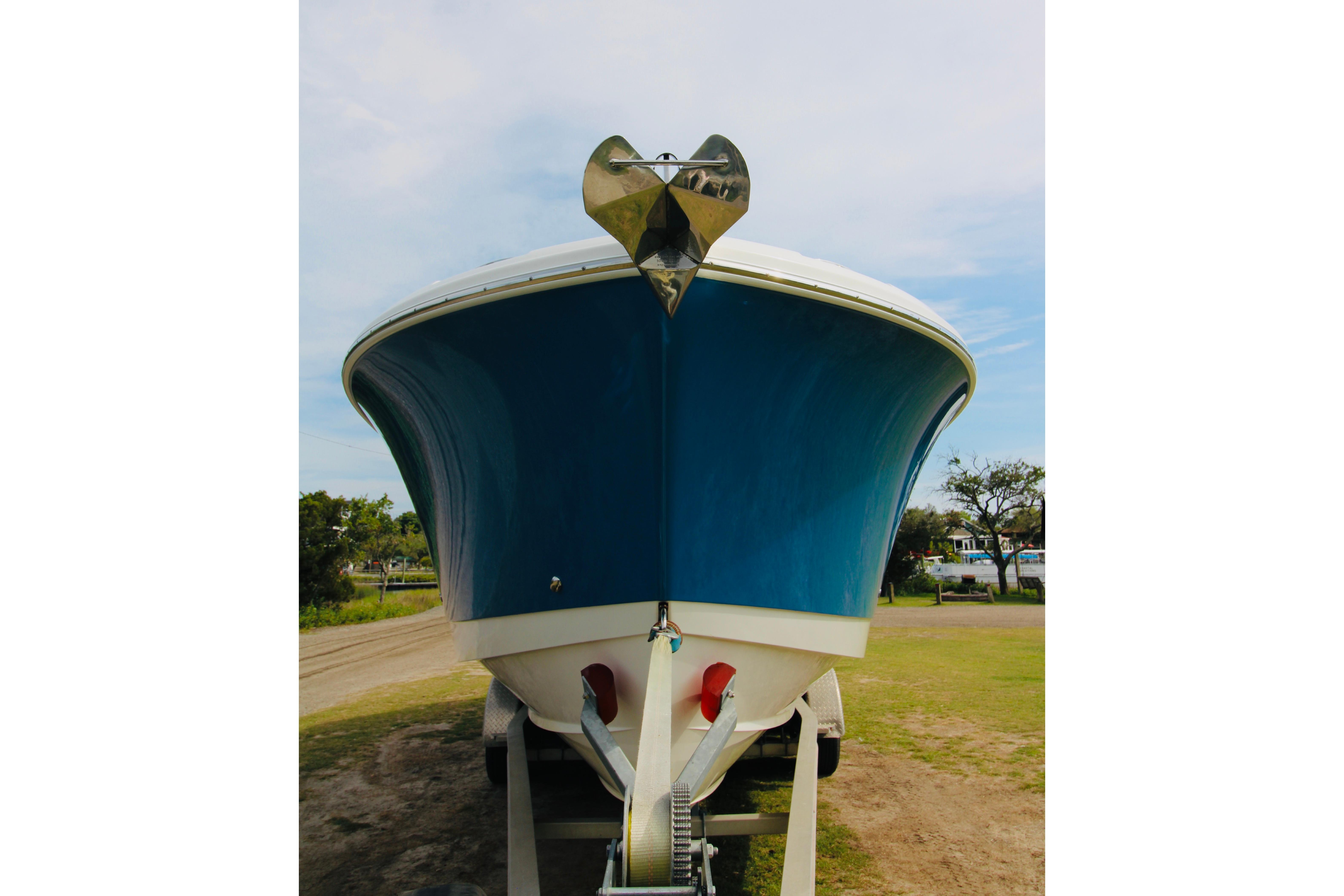 2022 Edgewater 280CC boat on trailer, front view, blue hull, outdoors.
