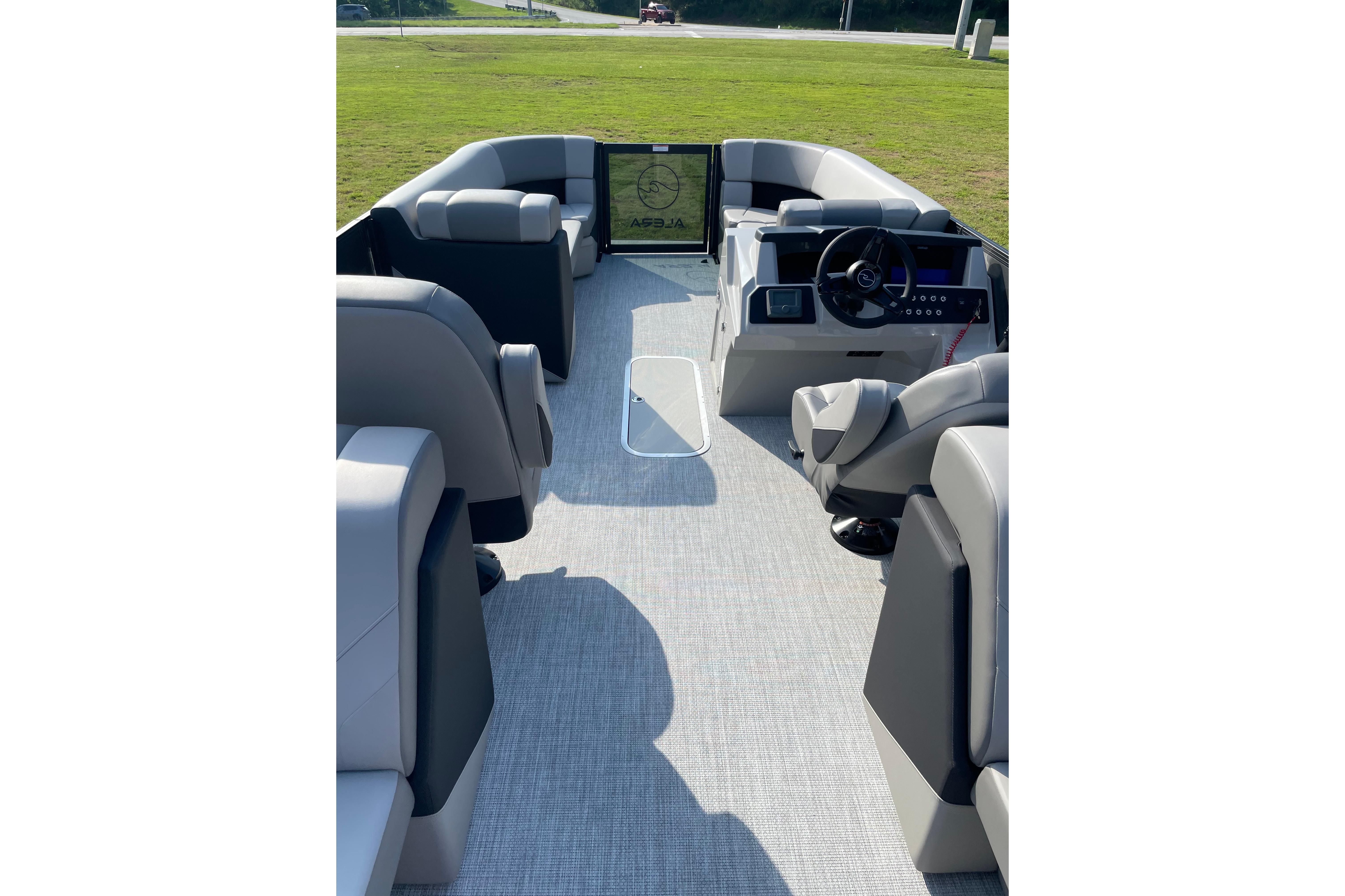 Interior view of a 2027 Alera a24 boat with modern seating and steering console.