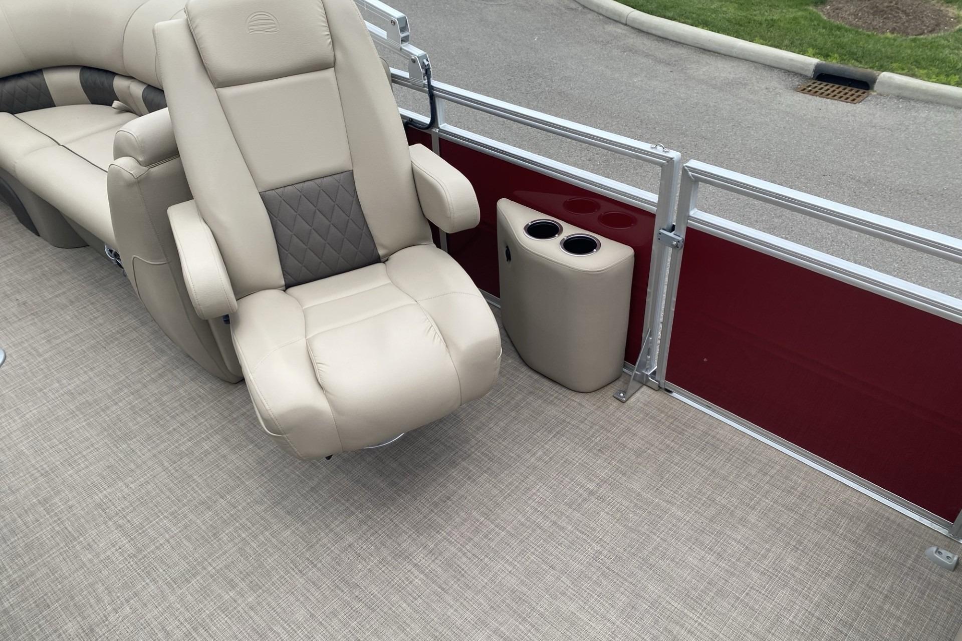 2024 Sun Tracker Party Barge 22 DLX interior with beige seating and cup holders.