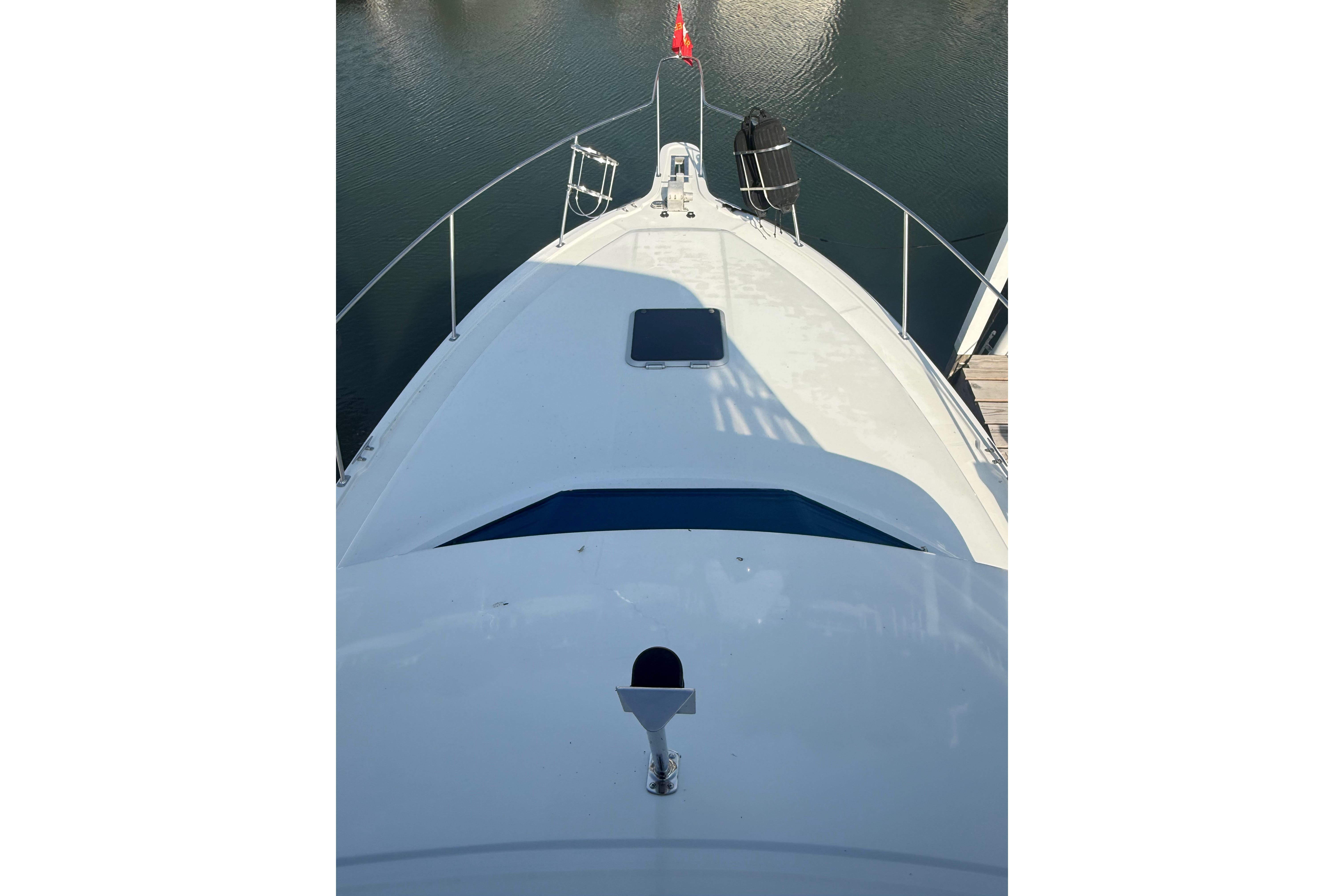 1992 Carver 33 Aft Cabin Motor Yacht bow view, docked on calm water.